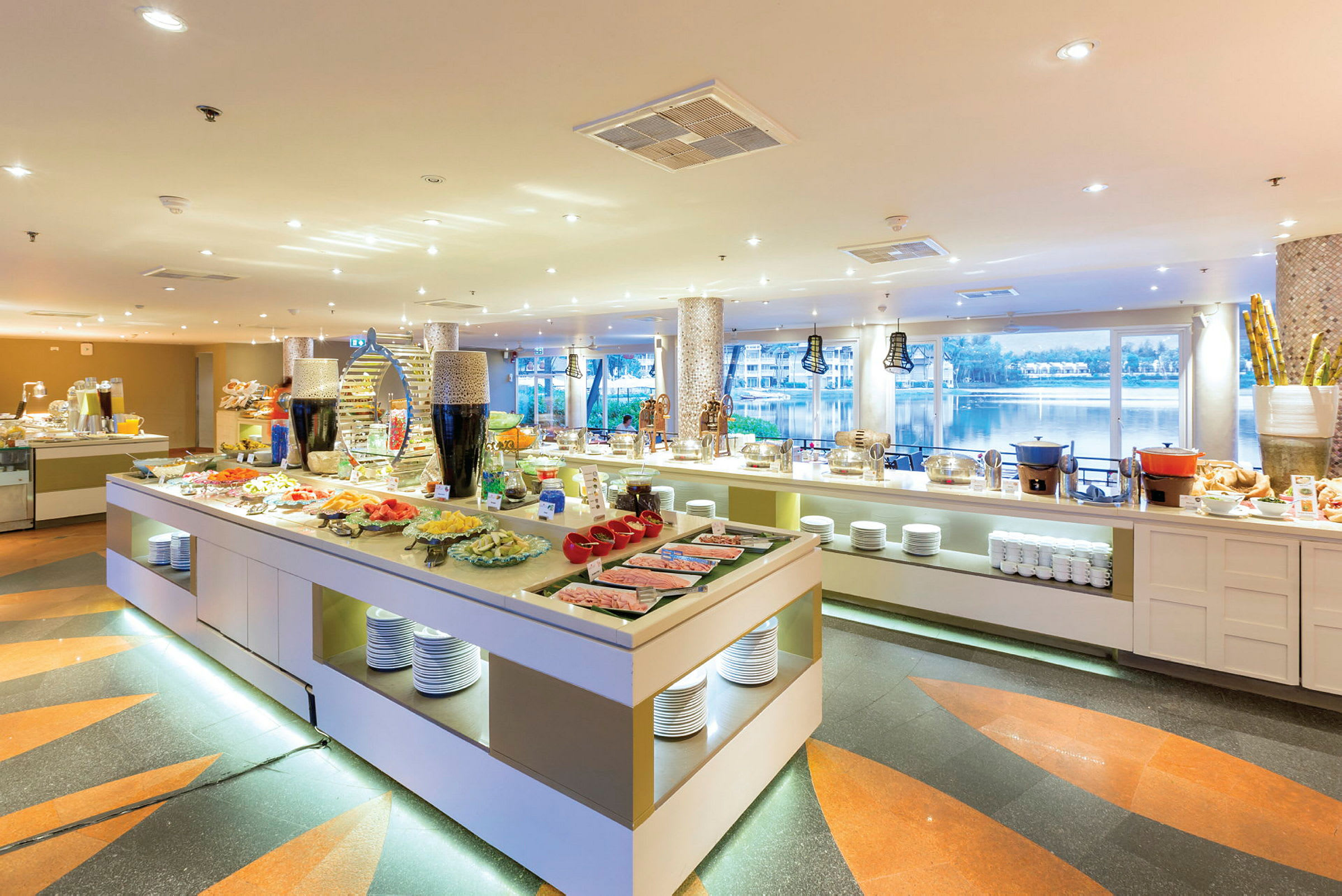 En romslig bufférestaurant med ulike retter og panoramautsikt over et vannområde. (AI-generert tekst)