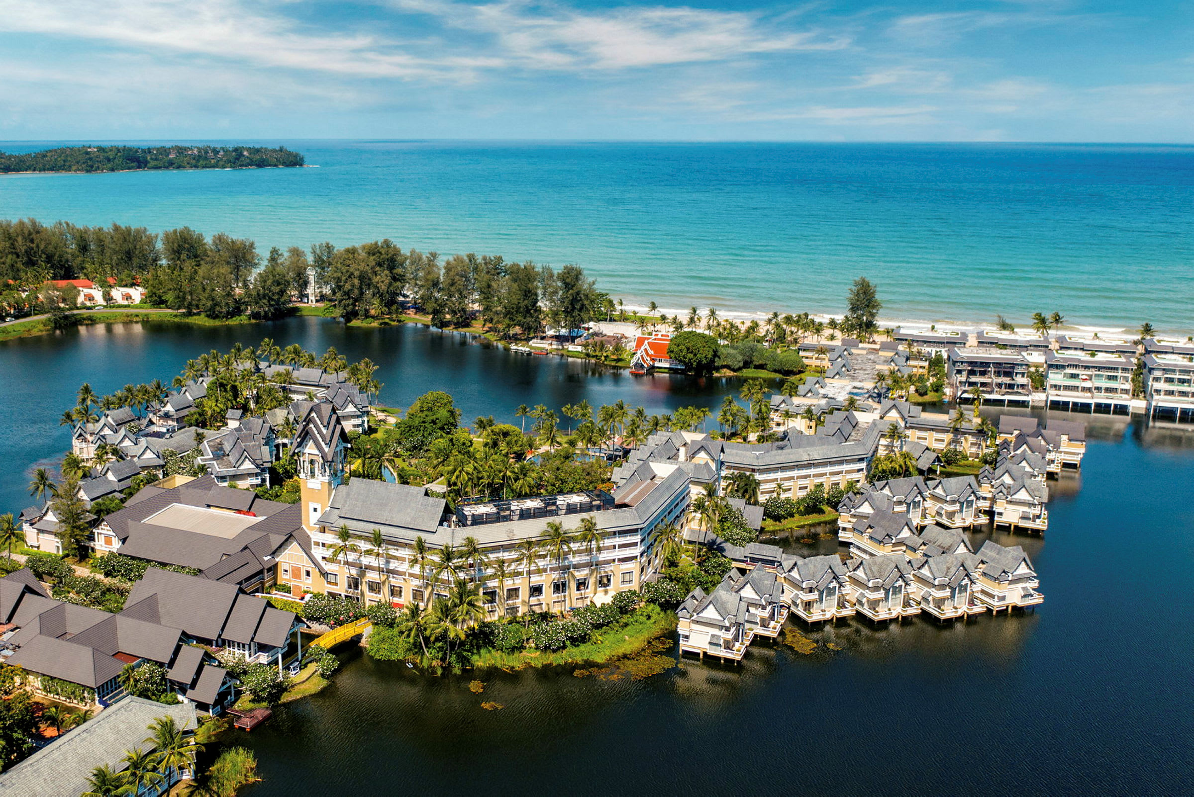 Hotellområde plassert ved en lagune nær en strand. (AI-generert tekst)