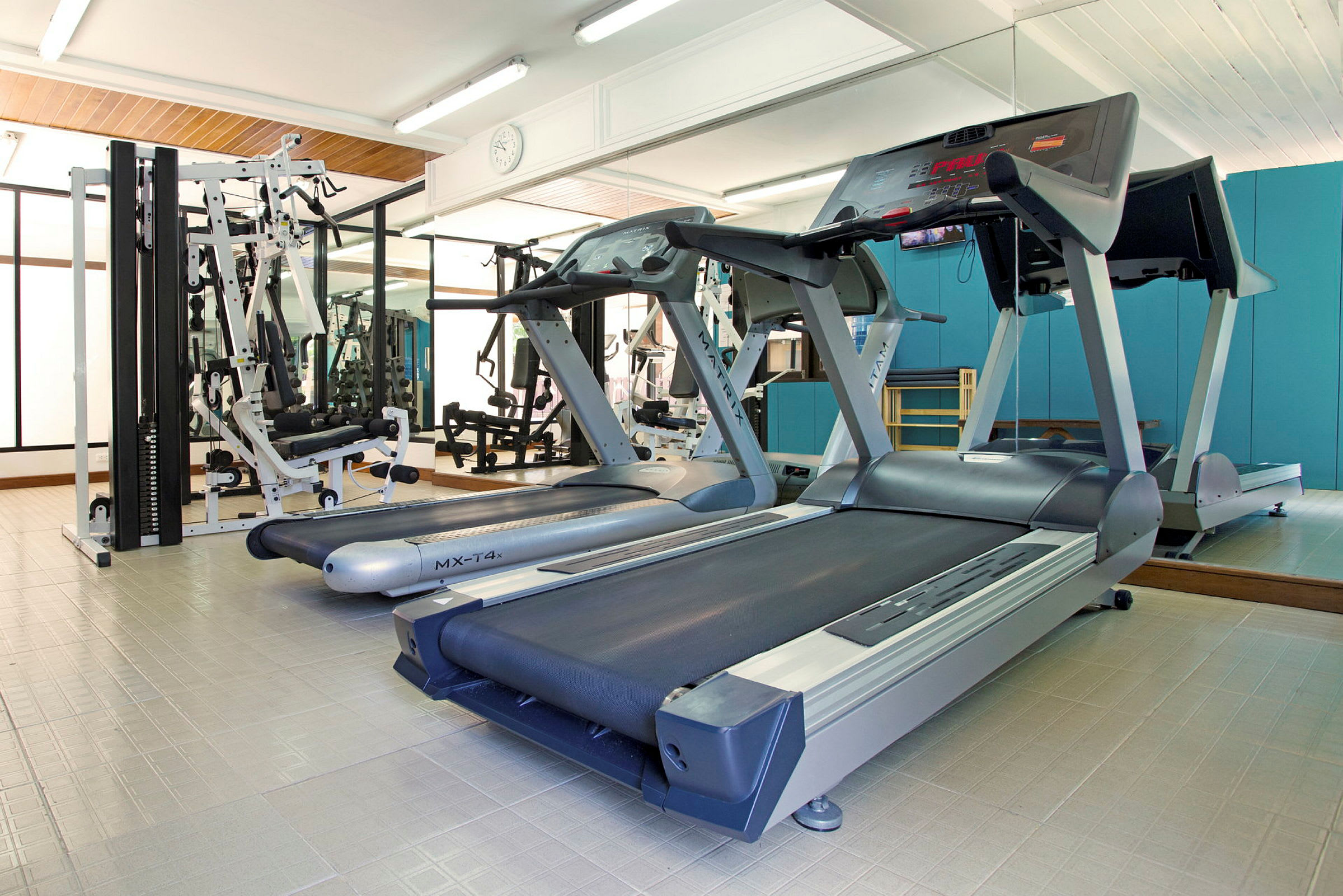 Gym med tredemøller og treningsmaskiner. (AI-generert tekst)