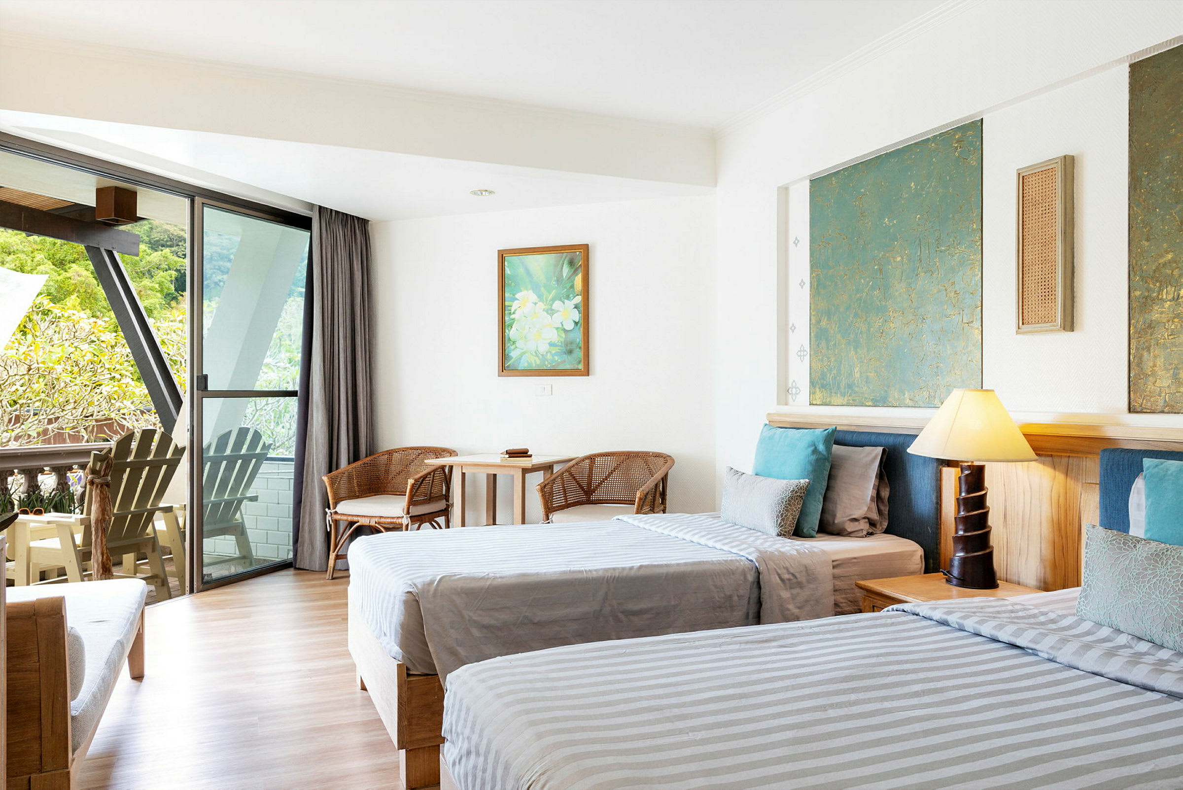 Hotellrom med to senger, sittemøbler og en balkong med utsikt. (AI-generert tekst)