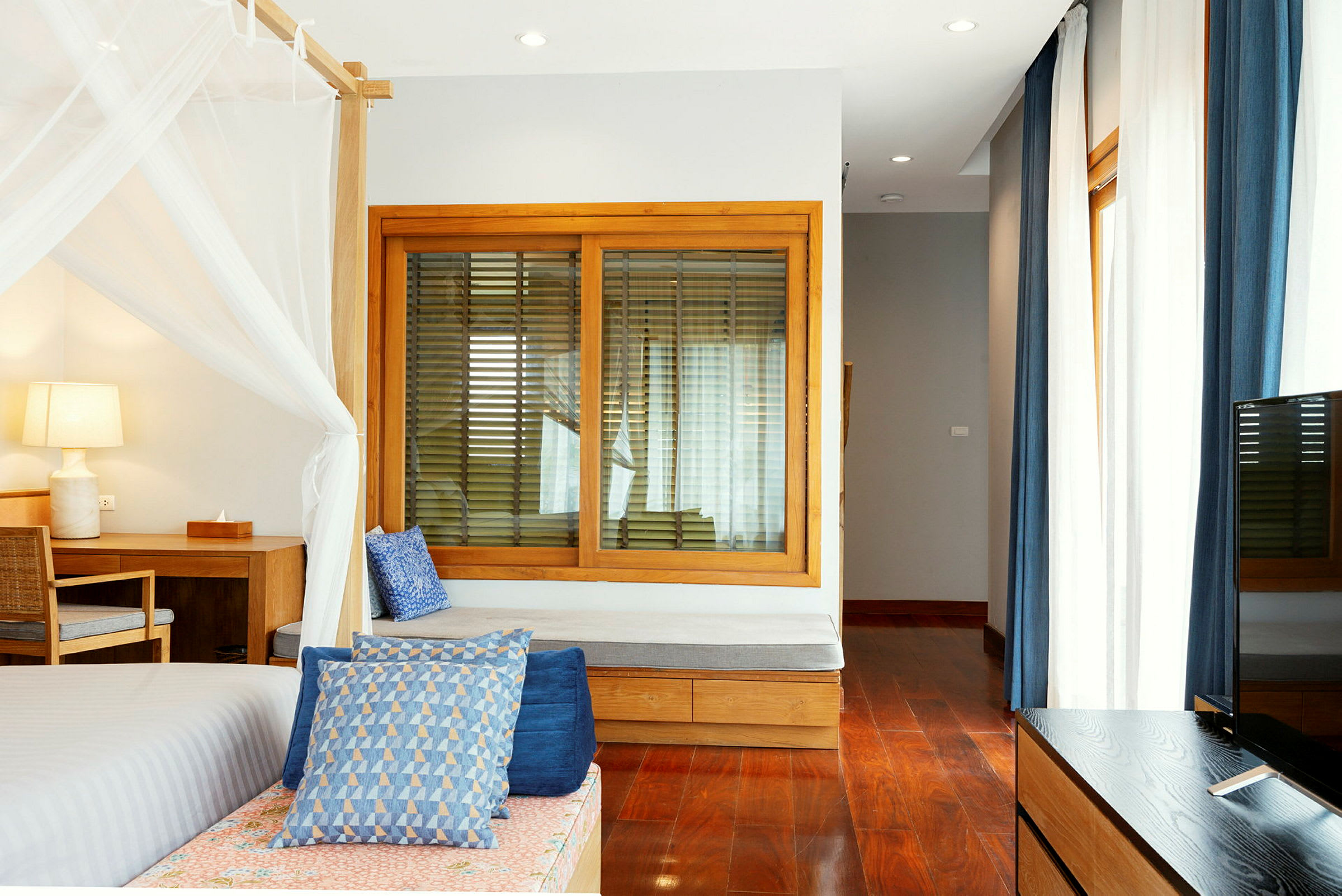 Et lyst og moderne hotellrom med tredetaljer og blå aksenter. (AI-generert tekst)
