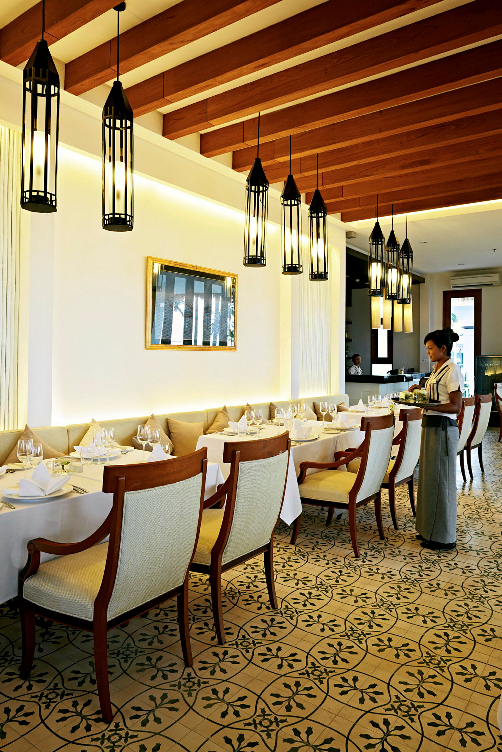 Elegant restaurant med dekkede bord og pendellamper i taket. (AI-generert tekst)