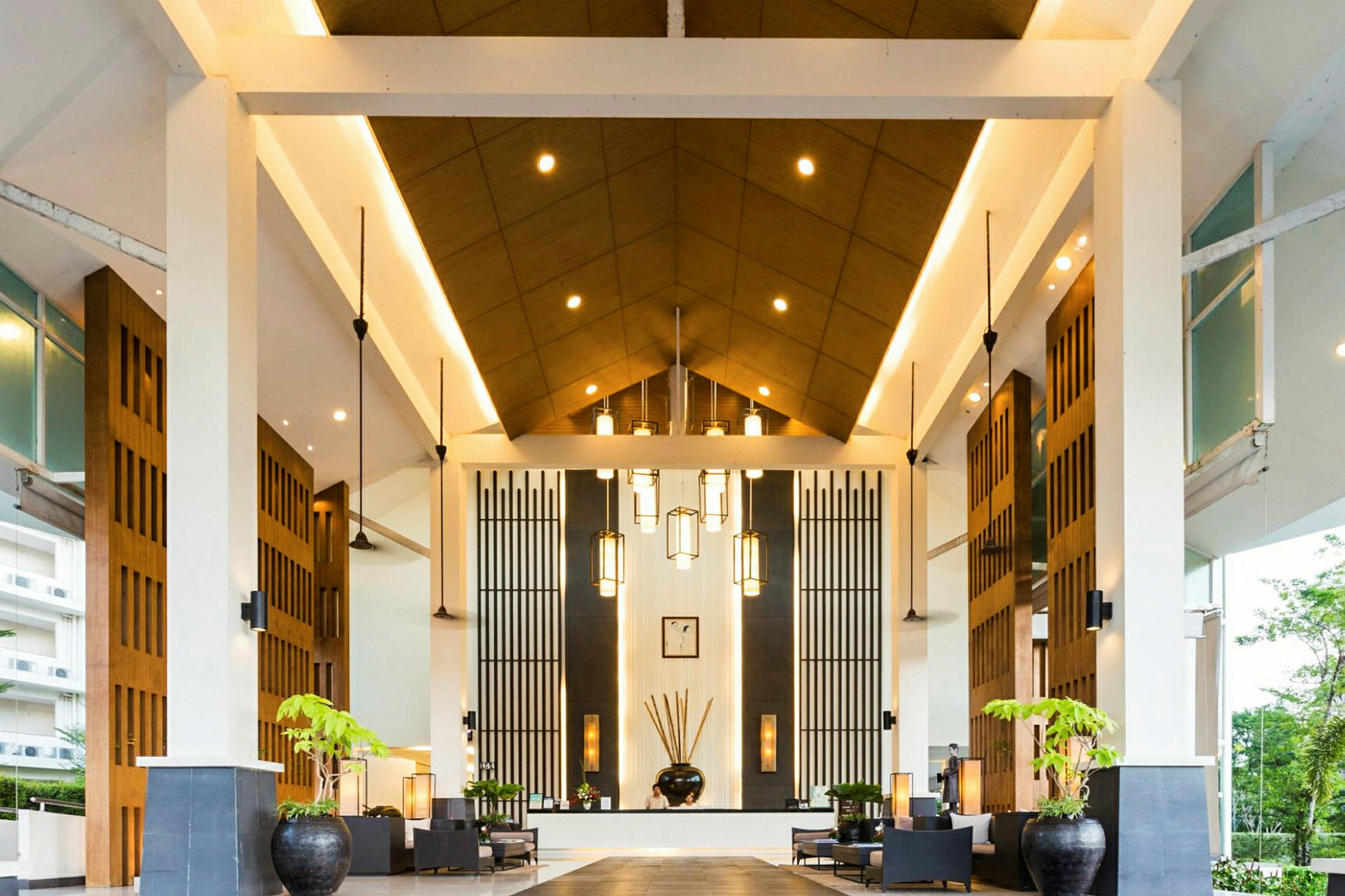 En hotellobby med høyt tak, moderne design og dekorative lamper. (AI-generert tekst)