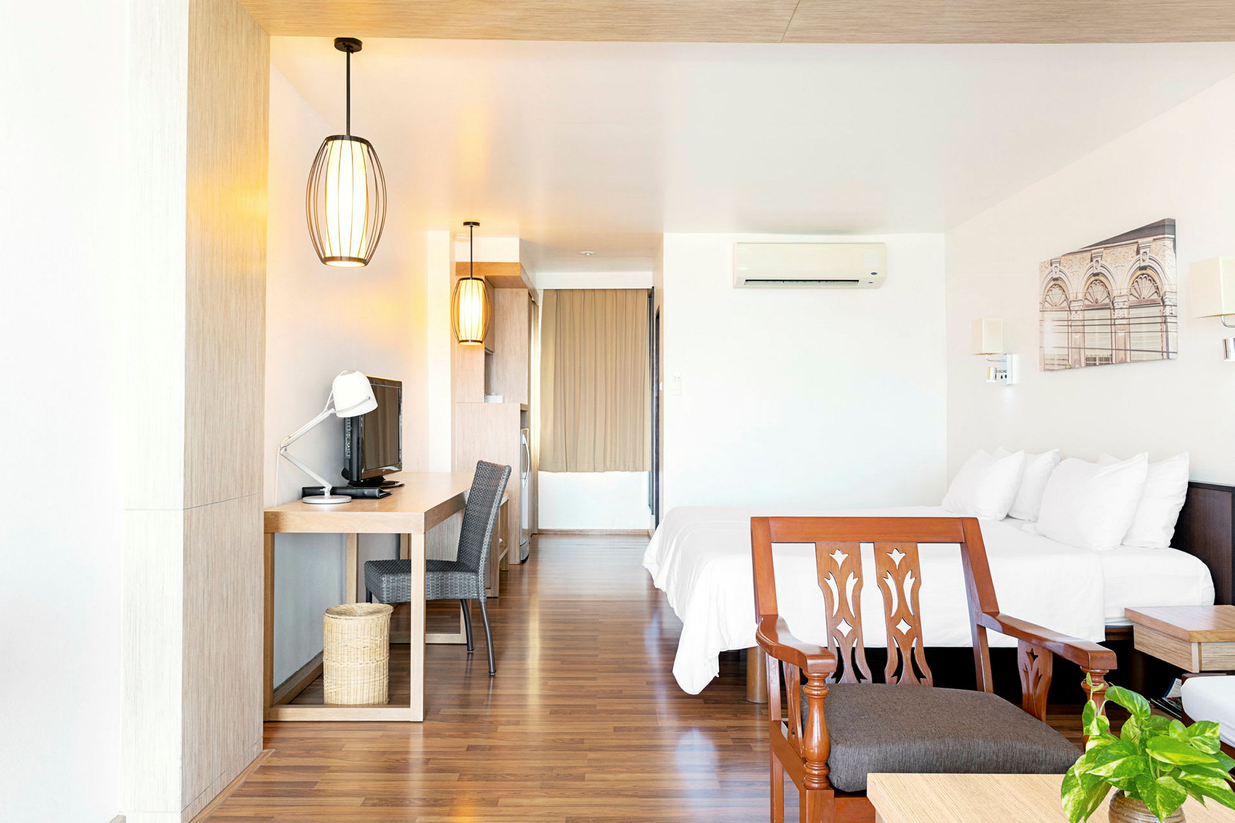 Hotellrom med dobbeltseng, skrivebord, TV og stol. (AI-generert tekst)