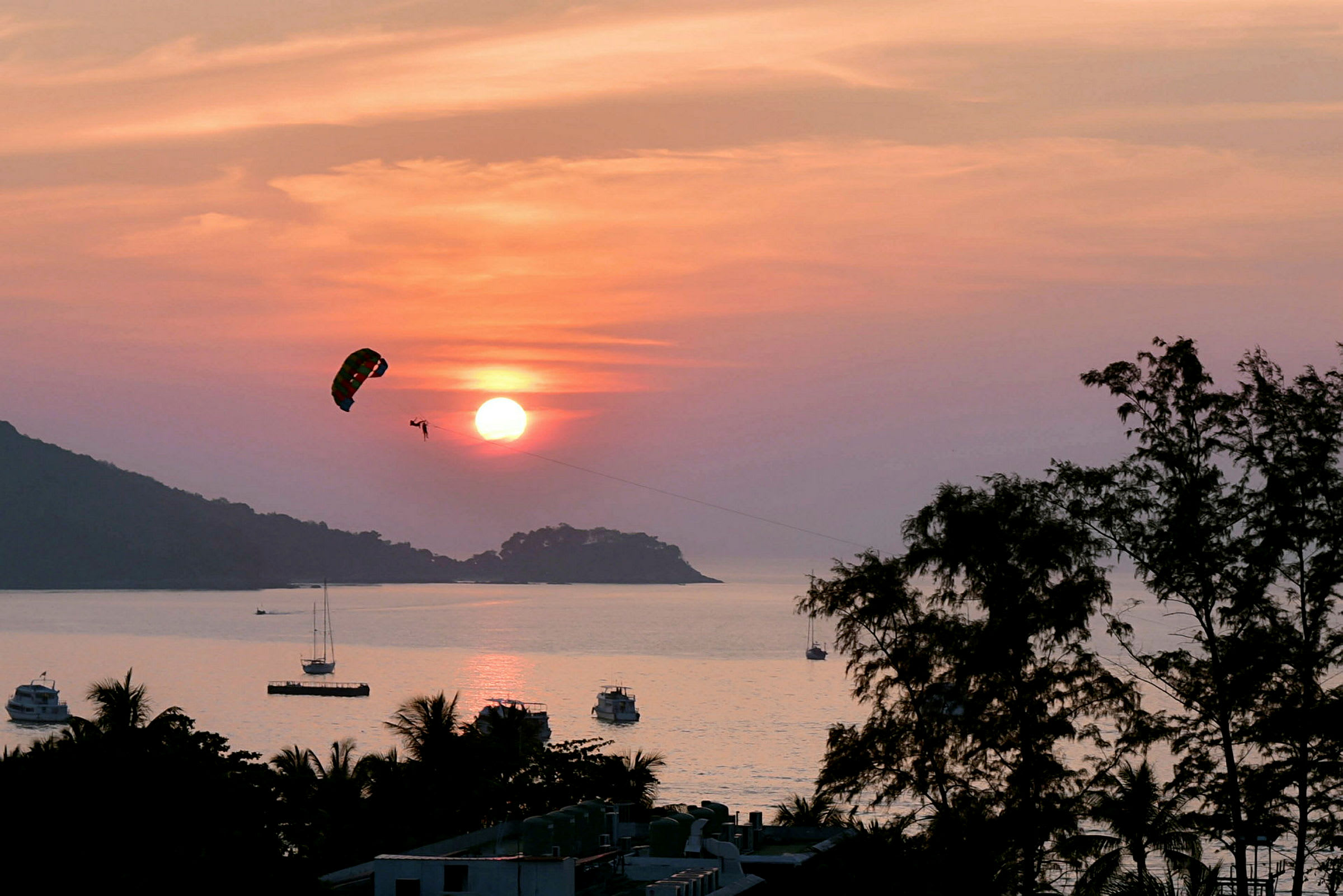 Person som driver med parasailing over havet ved solnedgang. (AI-generert tekst)