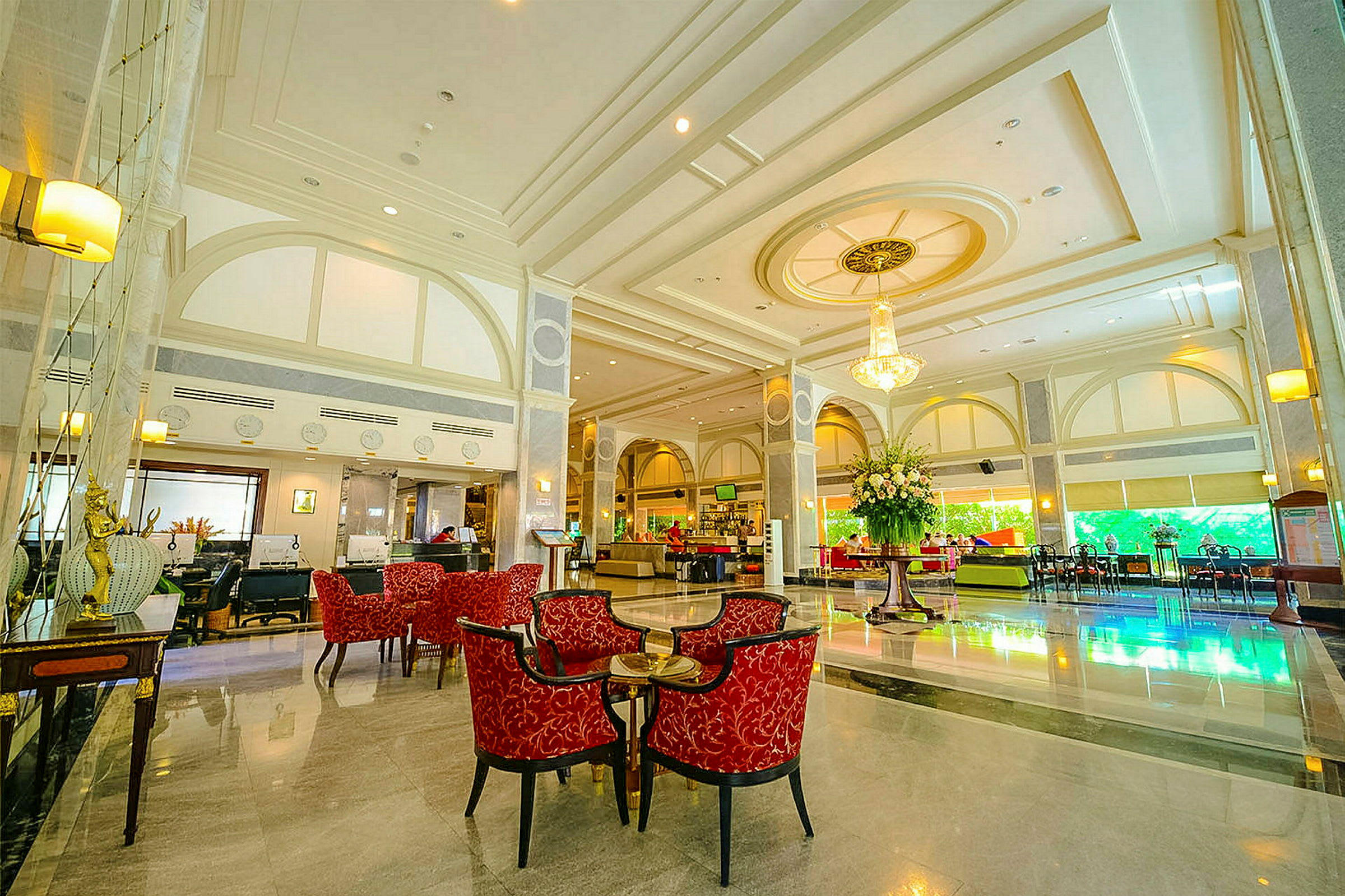 Elegant hotellobby med røde sittemøbler og en stor blomsterdekorasjon. (AI-generert tekst)