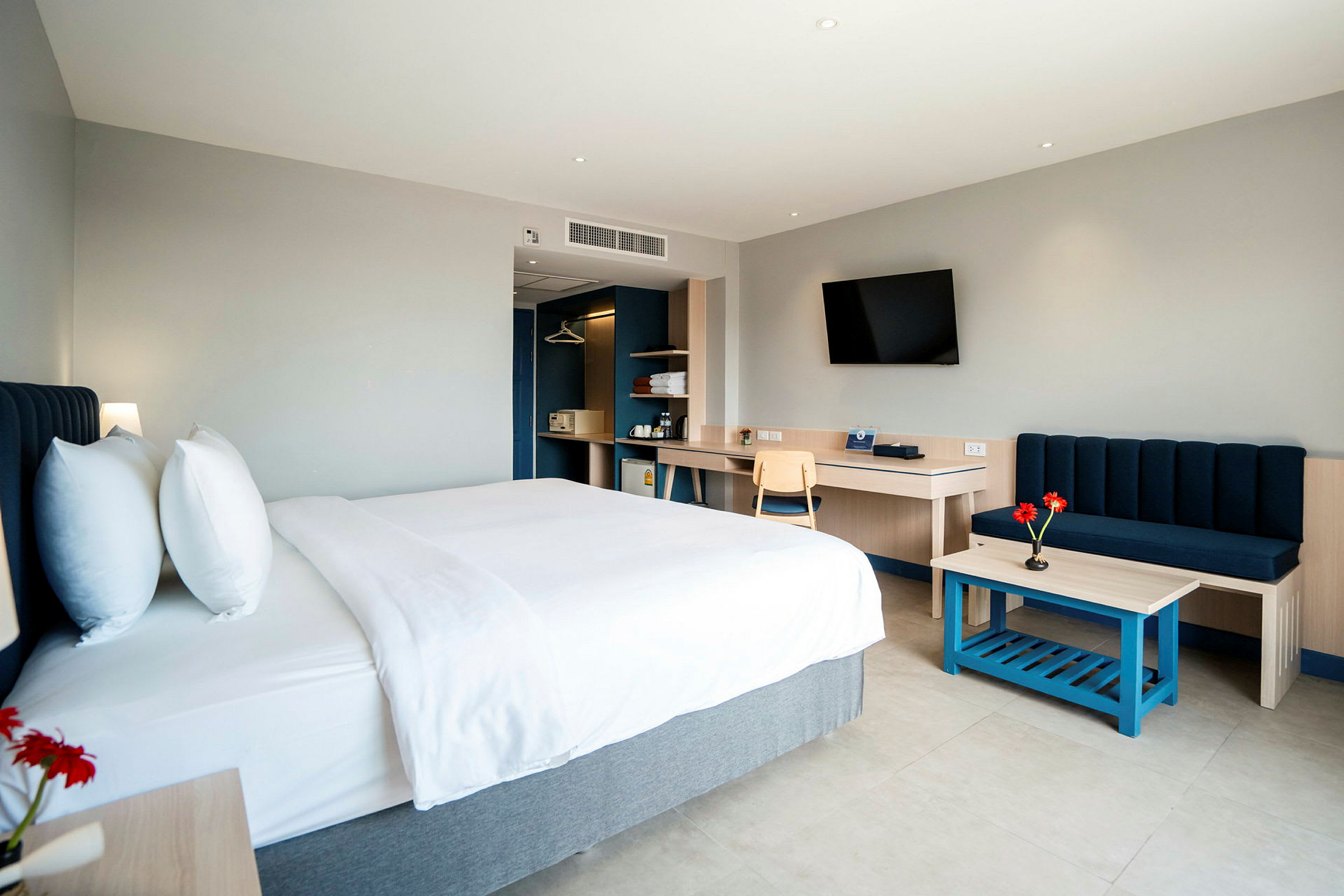 Et moderne hotellrom med en dobbeltseng, sofa og skrivebord. (AI-generert tekst)