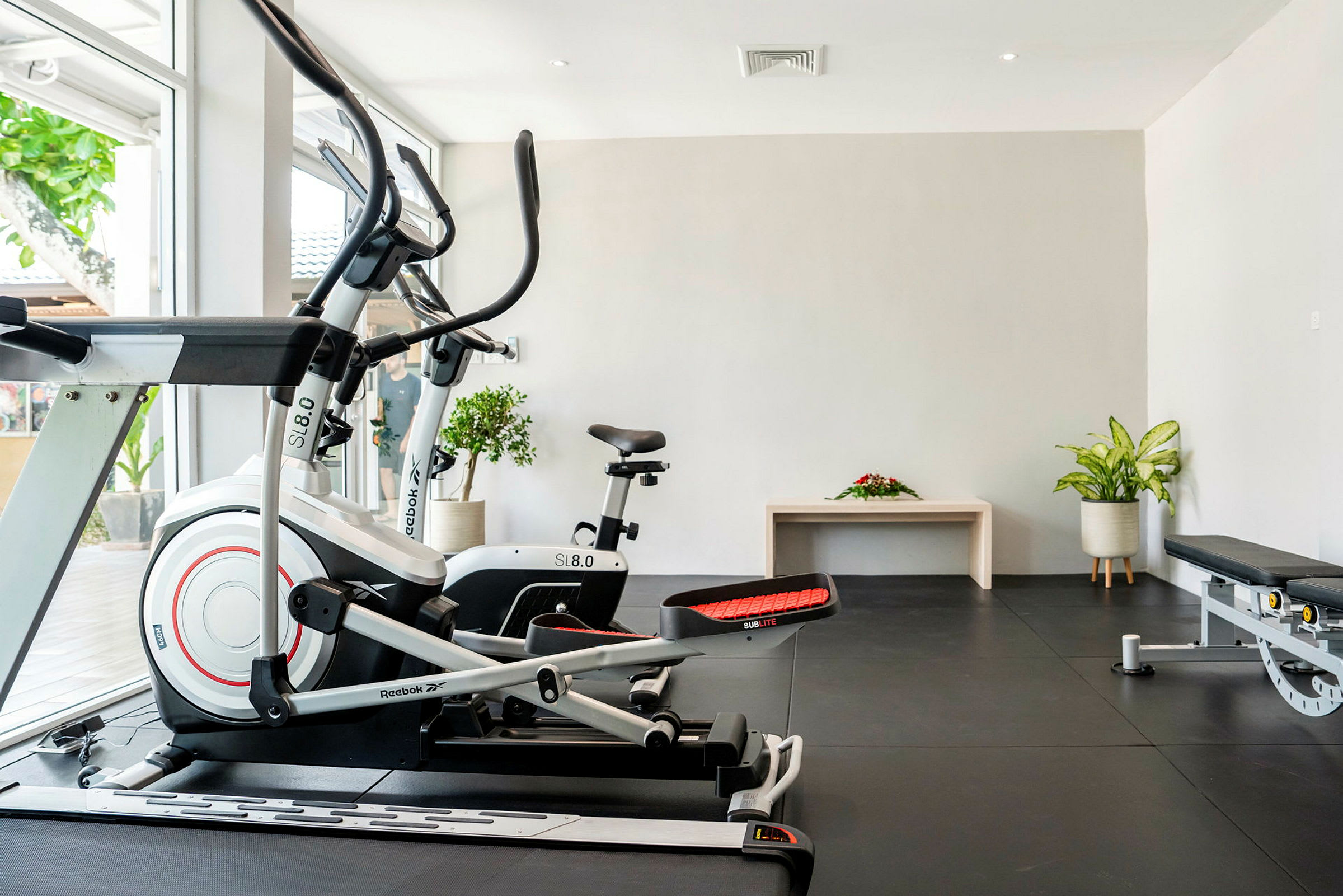 Gym med treningsmaskiner og planter. (AI-generert tekst)