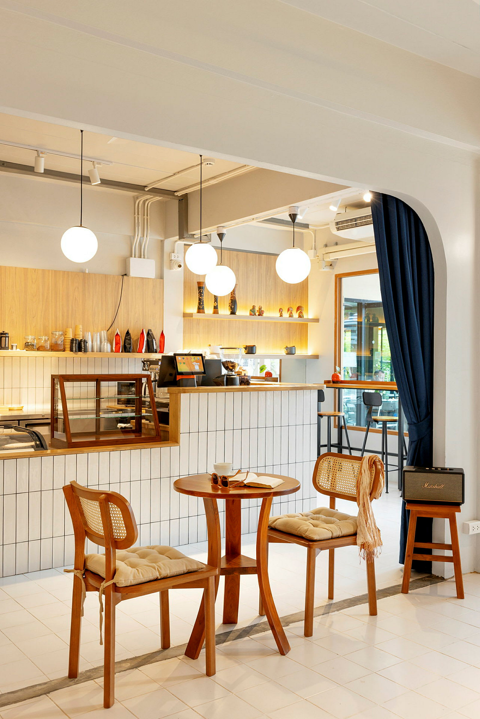 Bilde av en innredet kafe med trebord og stoler samt opplyste hyller. (AI-generert tekst)
