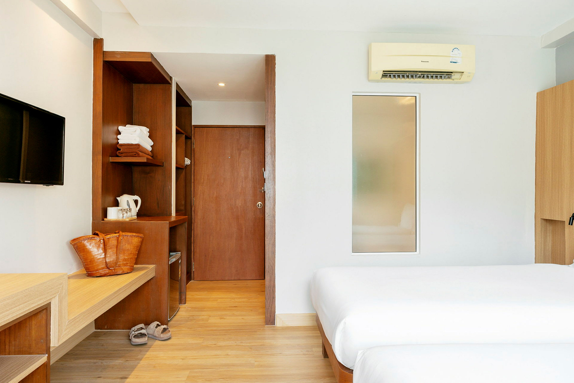 Hotellrom med to senger, tredetaljer og moderne innredning. (AI-generert tekst)