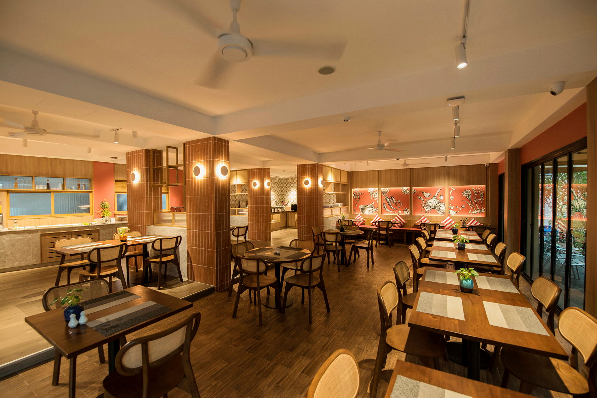 En restaurant med trebord og stoler, dekorert med røde vegger og kunstverk. (AI-generert tekst)