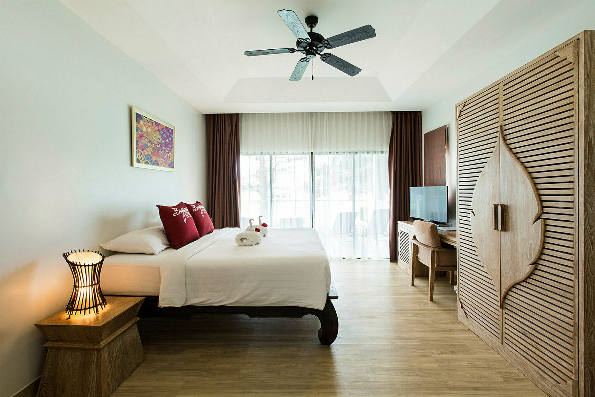 Et lyst hotellrom utstyrt med en seng, nattbord, garderobe og skrivebord med stol. (AI-generert tekst)