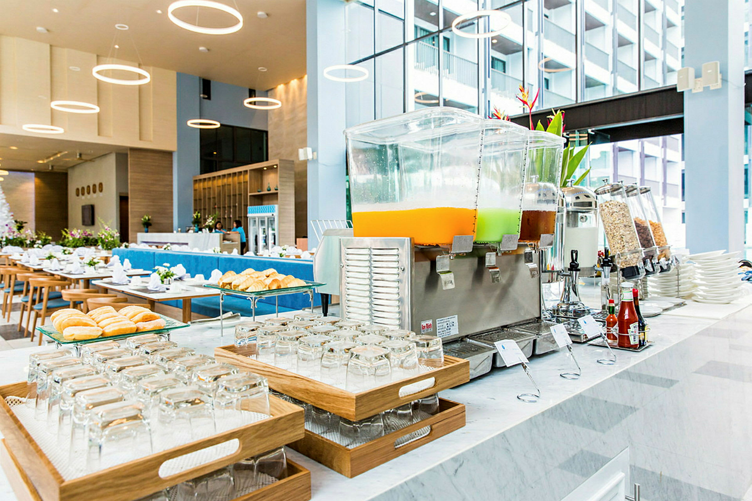 Frokostbuffé med juiceautomater og bakverk på et moderne hotell. (AI-generert tekst)