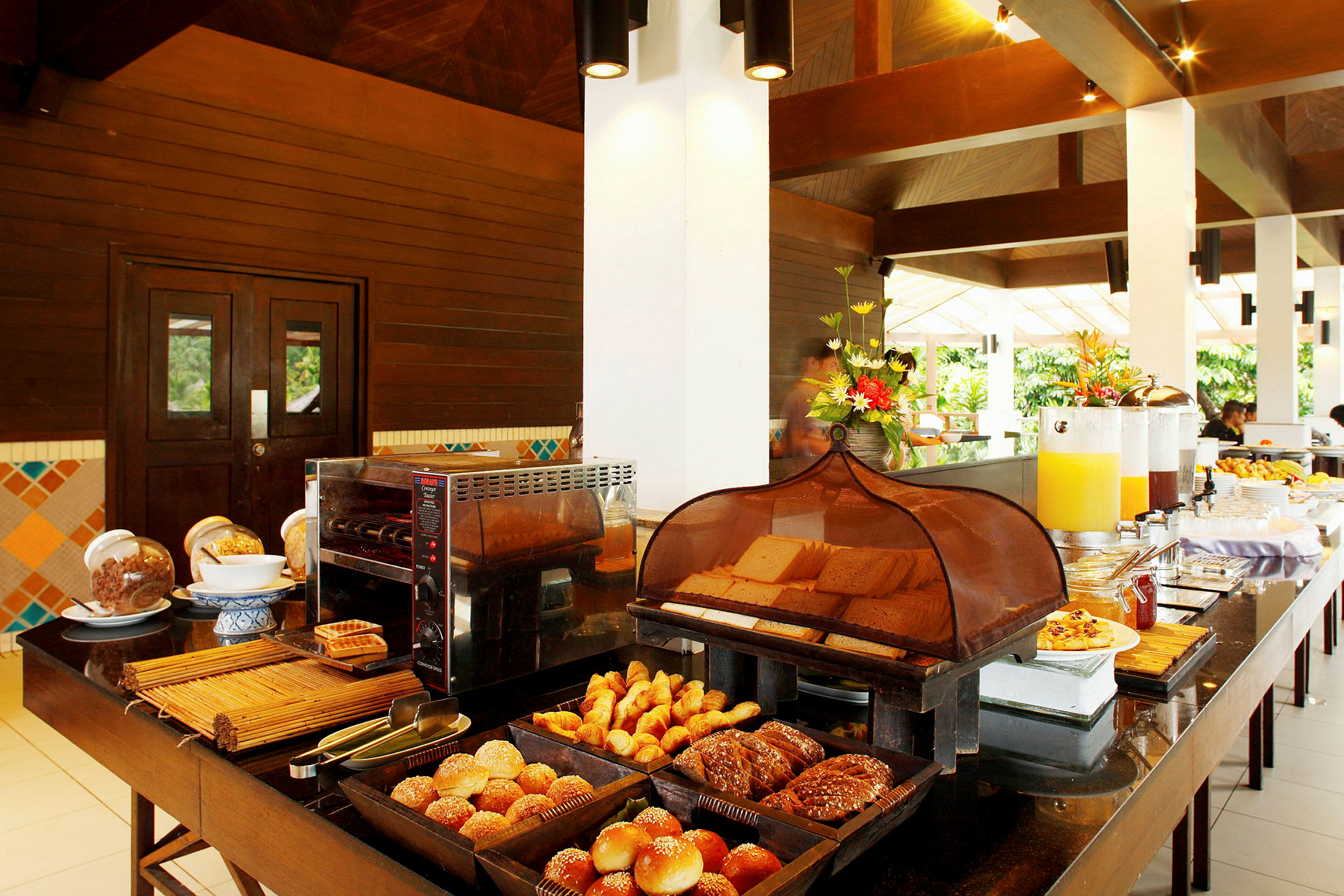 Hotellfrokost med brød, croissants og drikker på en buffébord. (AI-generert tekst)