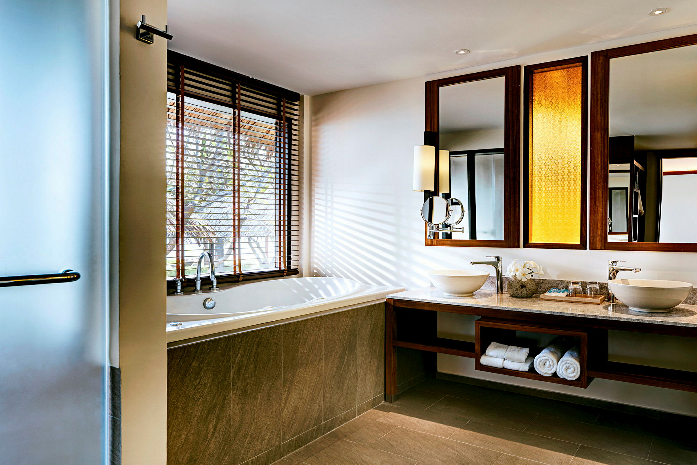 Et moderne bad med boblebad, to vasker og store speil. (AI-generert tekst)