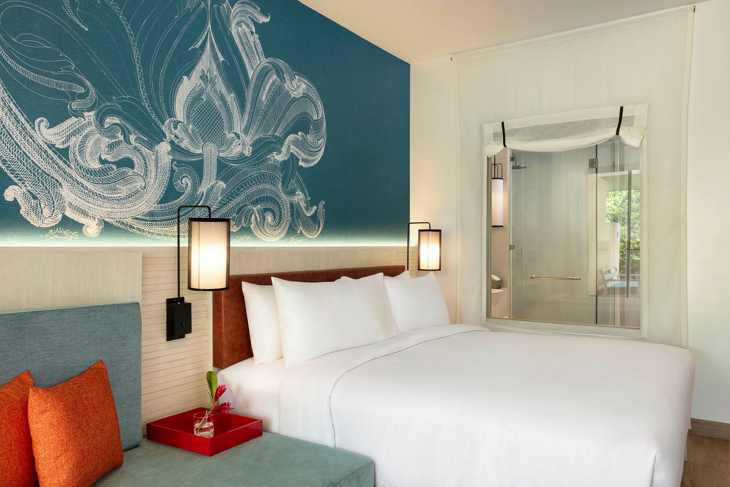 Et moderne hotellrom med en stor seng og fargerike puter. Veggdekorasjonen er detaljert og gir rommet en koselig atmosfære. (AI-generert tekst)