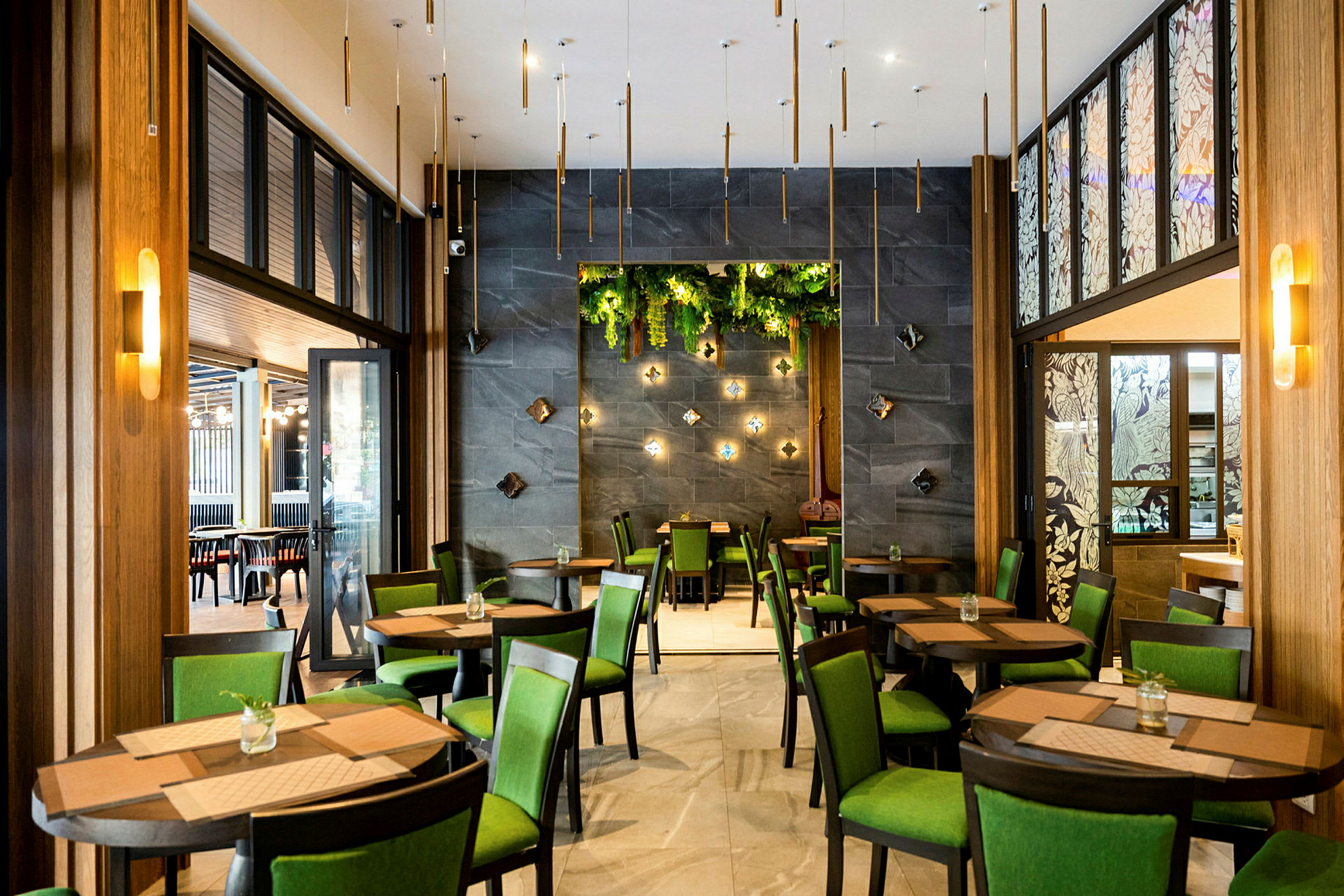 Restaurant med bord og stoler, grønne innslag og dekorative veggdetaljer. (AI-generert tekst)