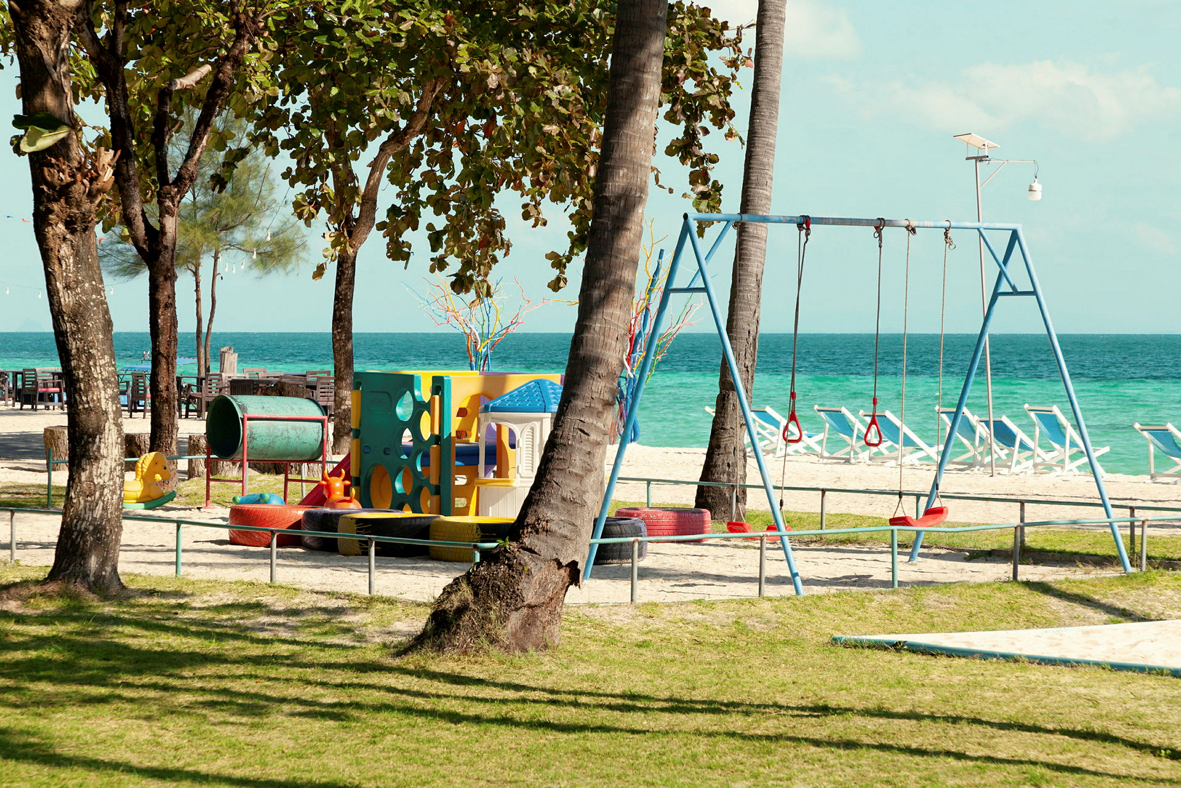 Lekeplass ved stranden med havutsikt. (AI-generert tekst)