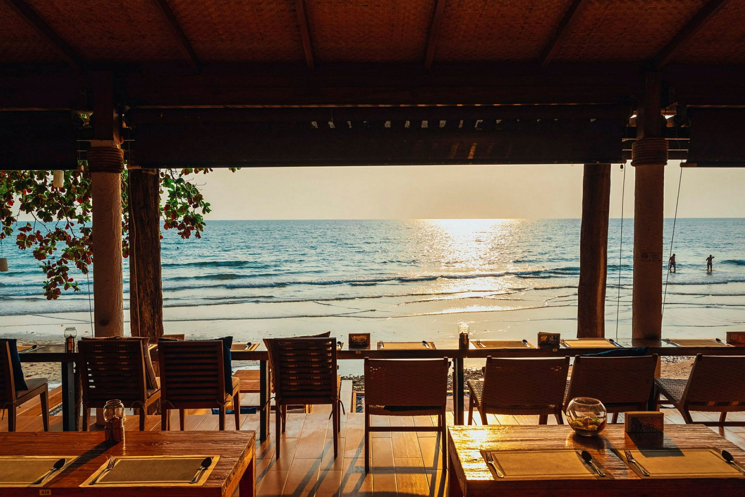 En restaurant med utsikt over stranden og havet i solnedgangen. (AI-generert tekst)