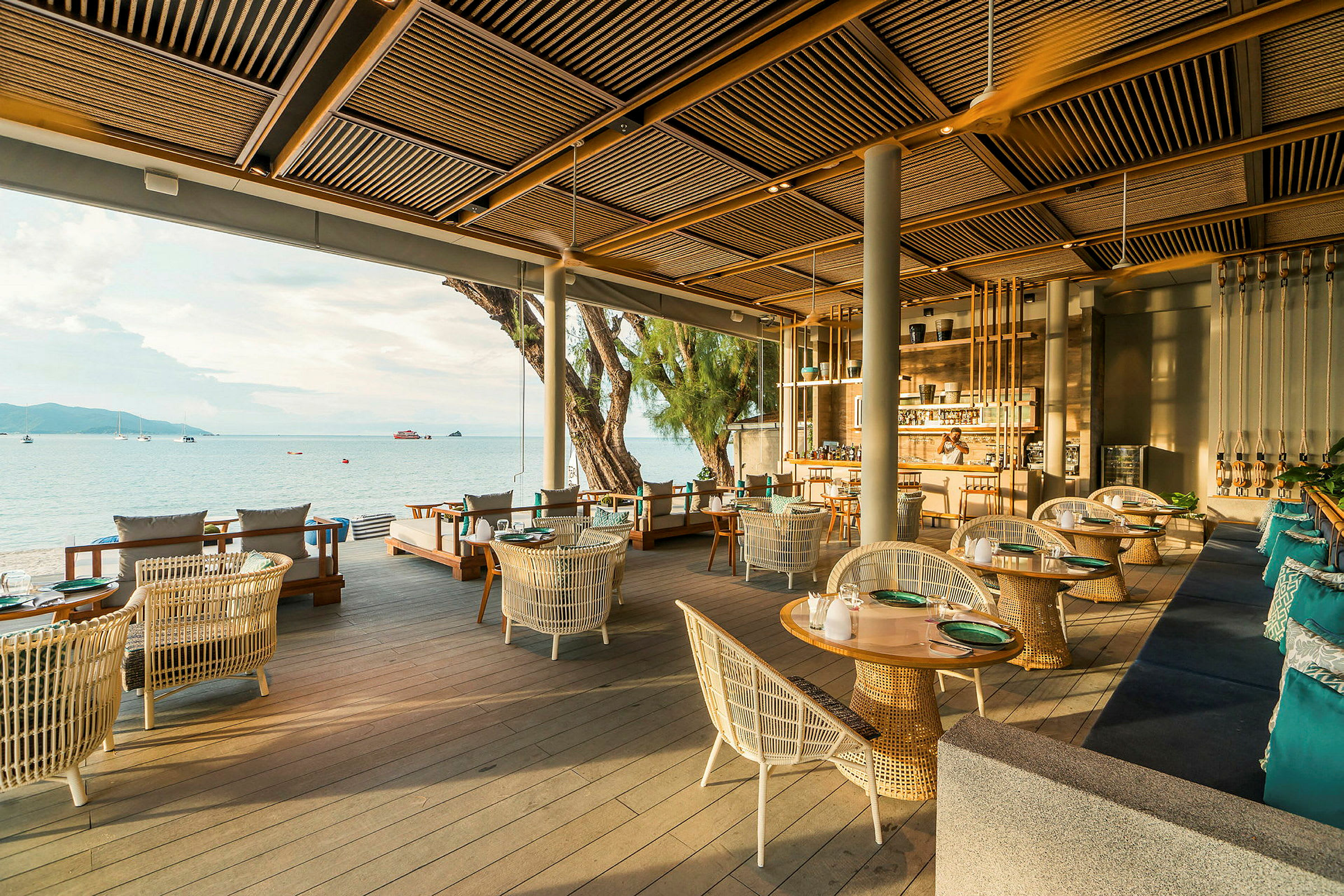 En elegant restaurant med utsikt over havet, innredet med moderne møbler og spredte bord og sittegrupper. (AI-generert tekst)