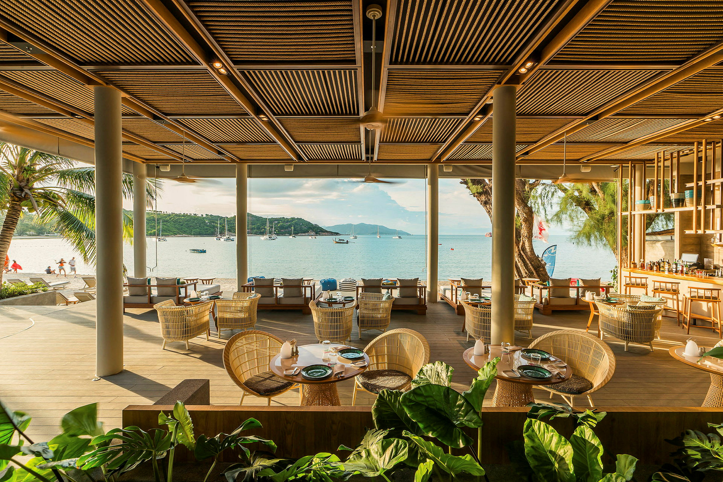 En restaurant ved stranden med sitteplasser og utsikt over havet. (AI-generert tekst)