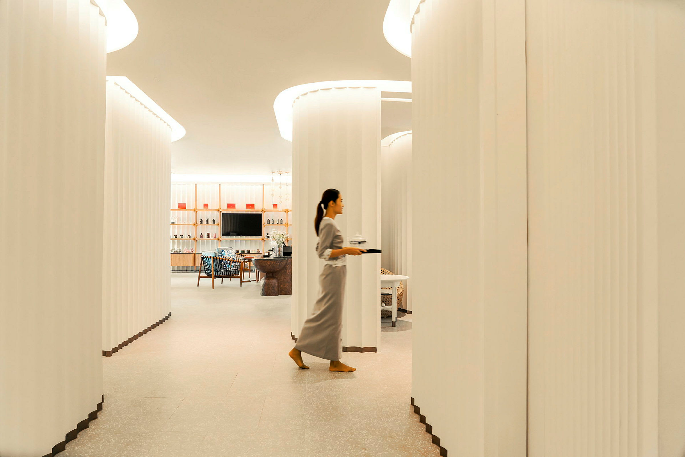 Et elegant innredet rom med hvite vegger, store bueganger og møbler i en moderne stil. (AI-generert tekst)