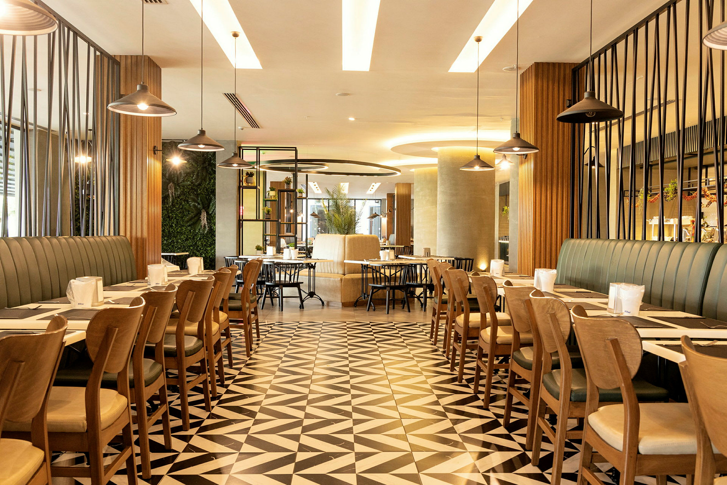 En moderne restaurant med geometriske gulvfliser, stilig innredning og bord organisert for servering. (AI-generert tekst)