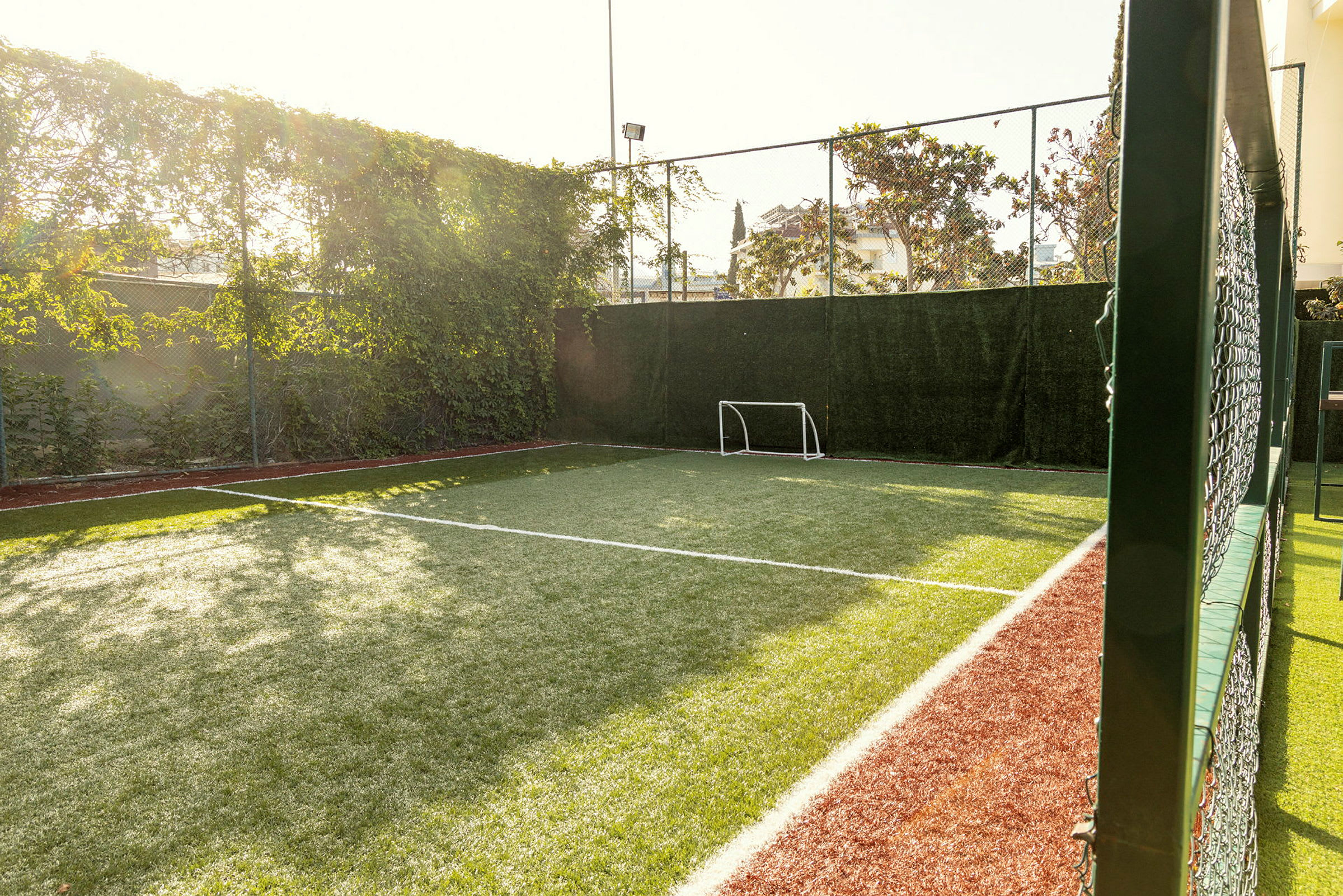 En liten fotballbane med gress og et mål. (AI-generert tekst)