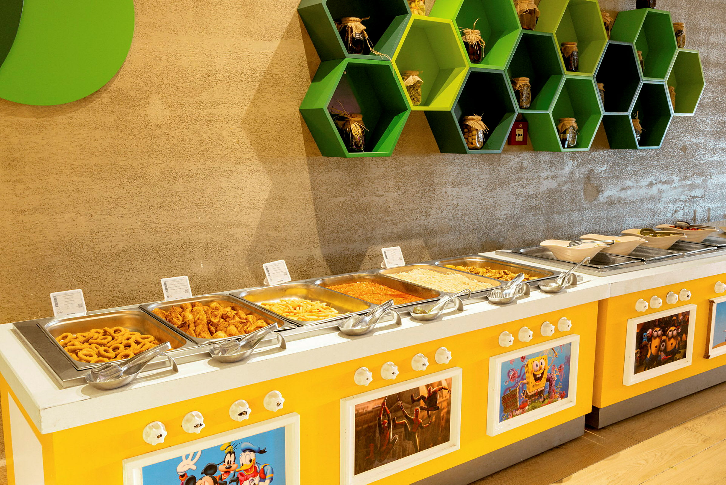 Buffet servert med forskjellige retter i en gul innredning. (AI-generert tekst)