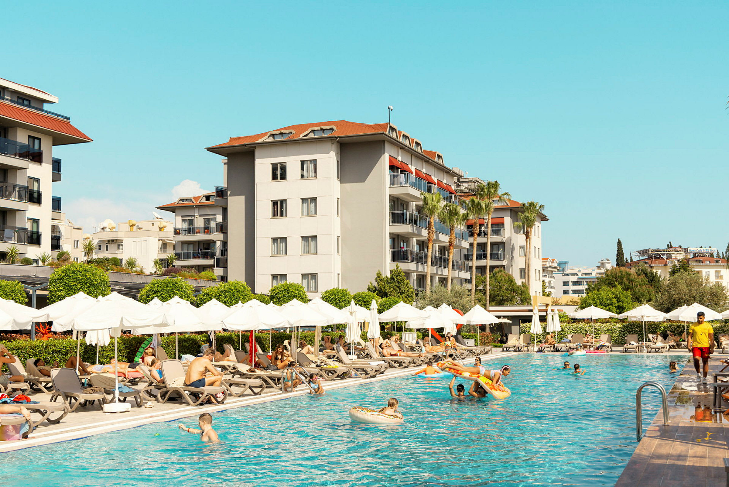 Utendørs bassengområde ved hotell med solsenger og parasoller. (AI-generert tekst)