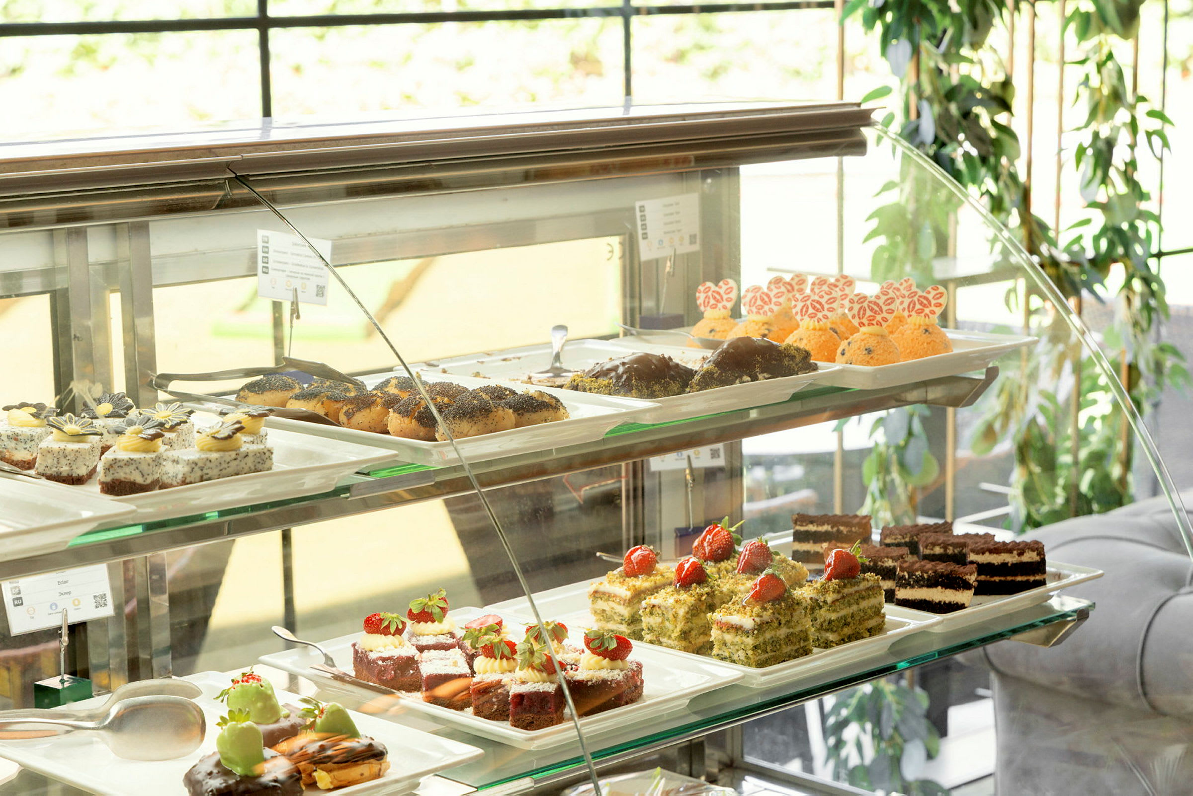 Et vitrineskap med forskjellige bakverk og desserter på fat. (AI-generert tekst)