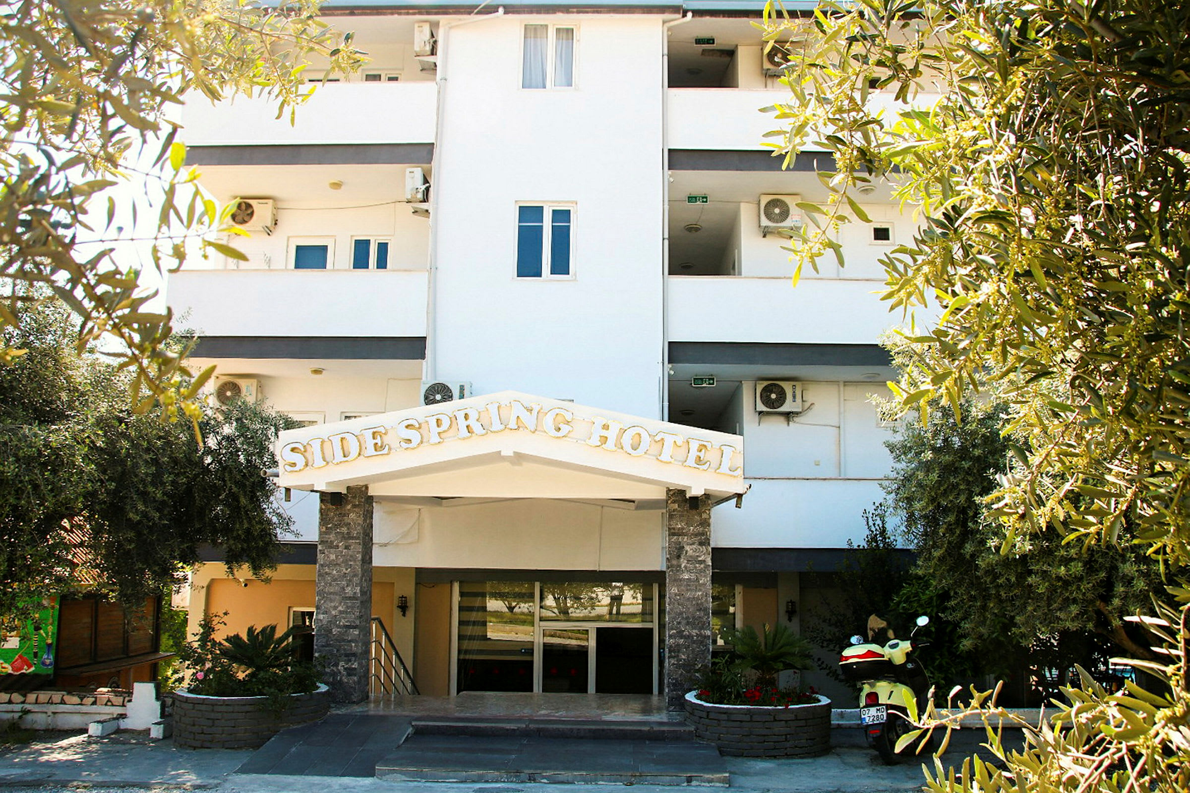 Bilde av en hotellbygning med et skilt som sier 'Side Spring Hotel'. (AI-generert tekst)