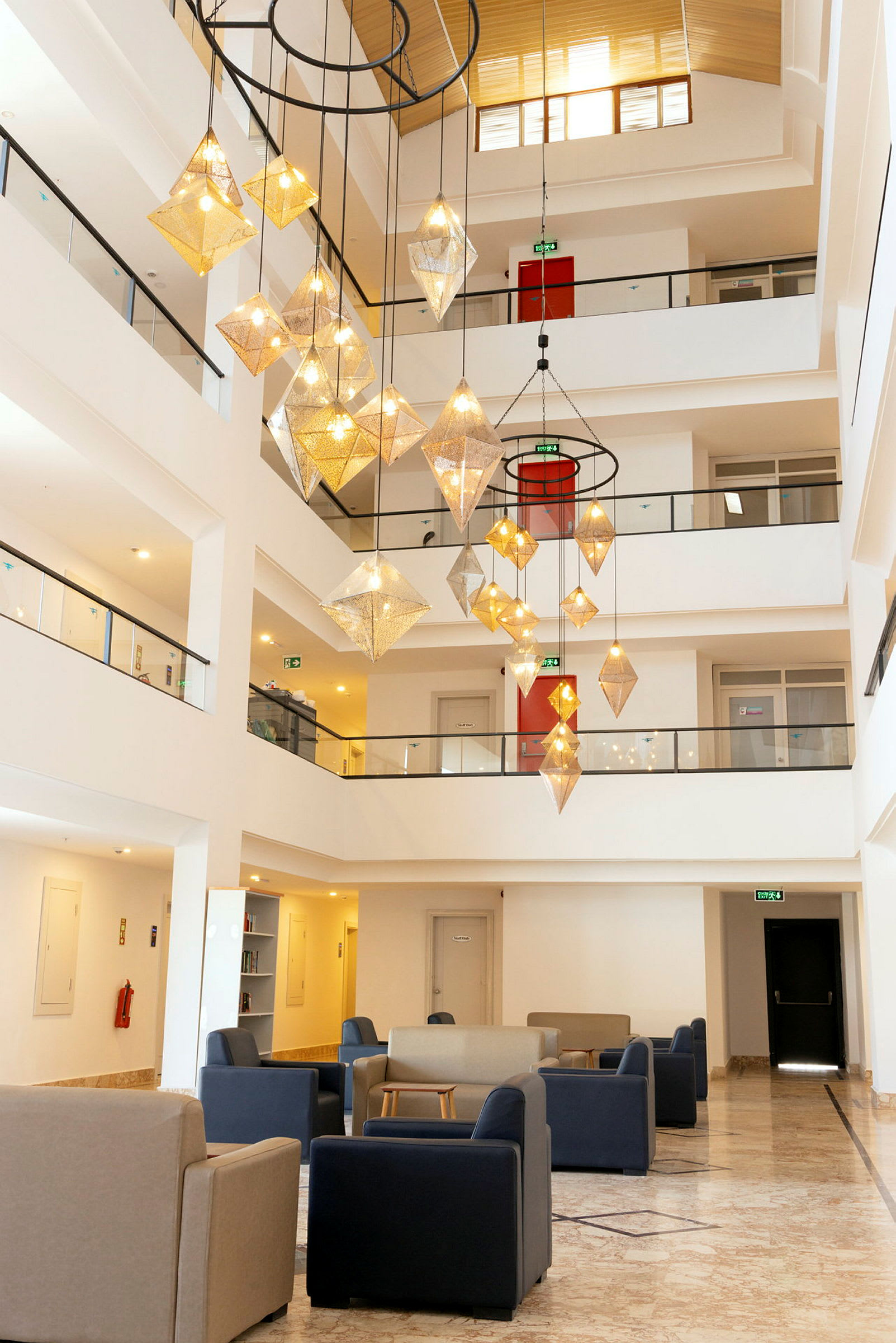 Interiør av et hotell med sitteplasser og en stor lysekrone. (AI-generert tekst)