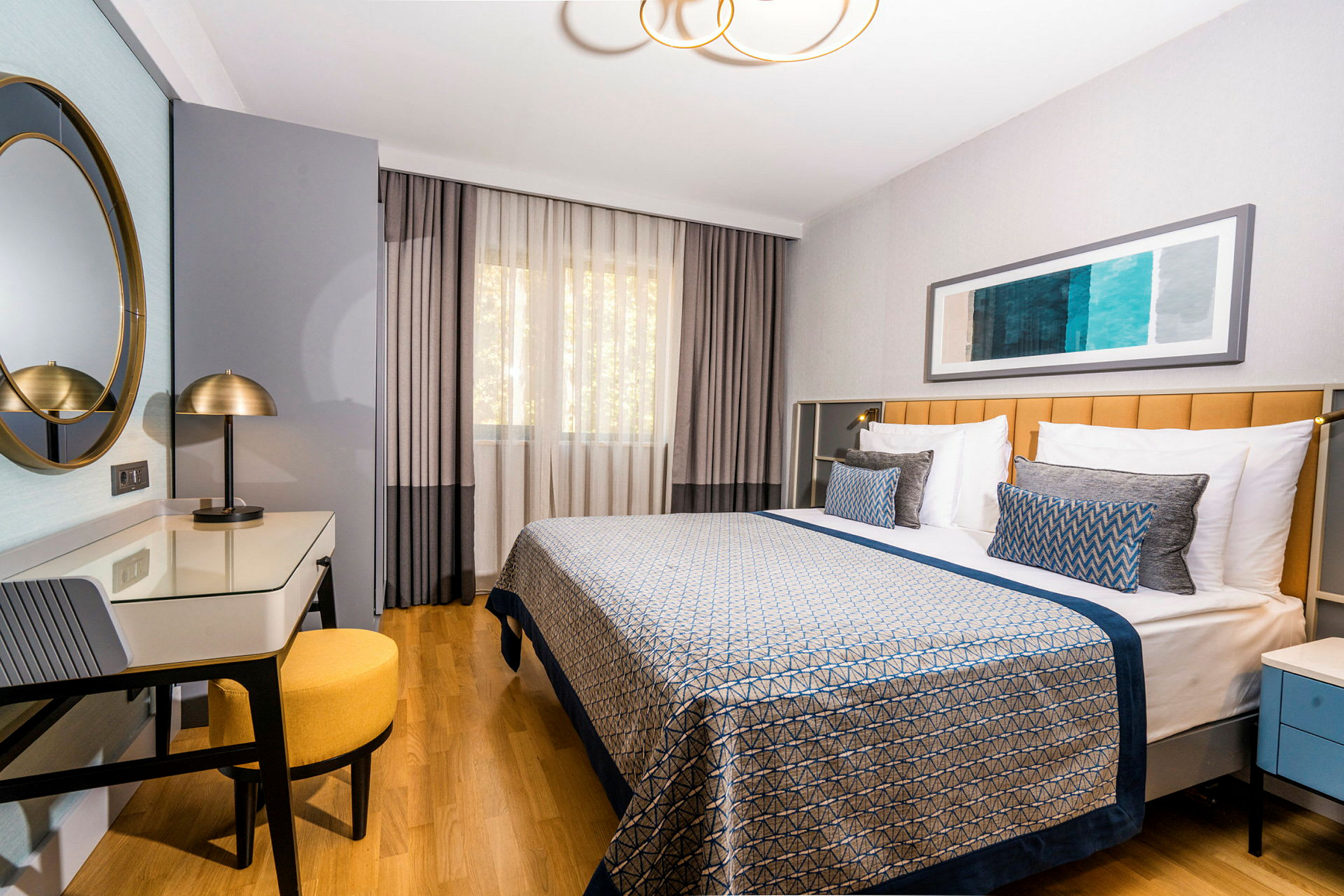 Et hotellrom med en dobbeltseng, skrivebord og stol. (AI-generert tekst)