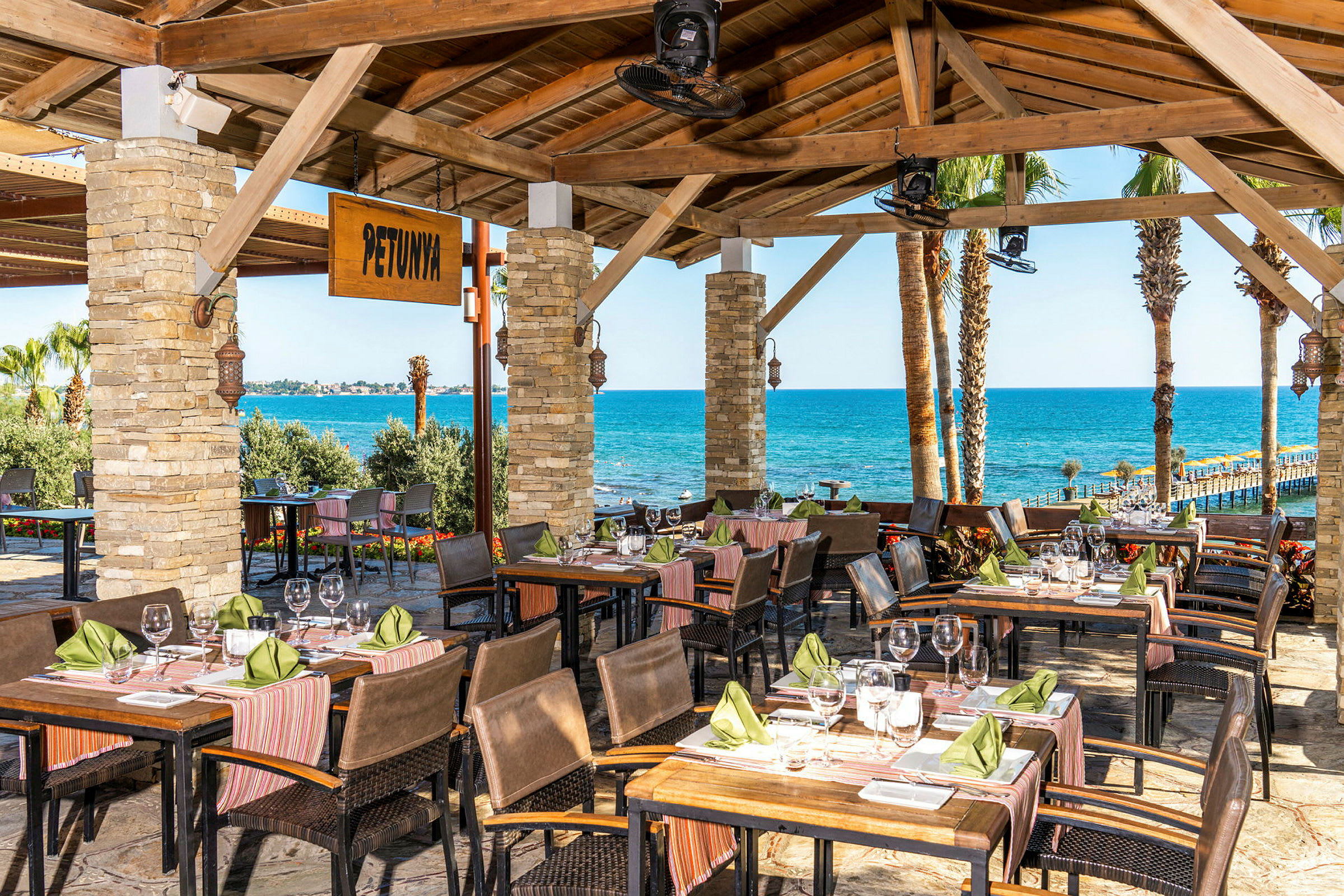 En restaurant med utsikt over havet og palmer. (AI-generert tekst)