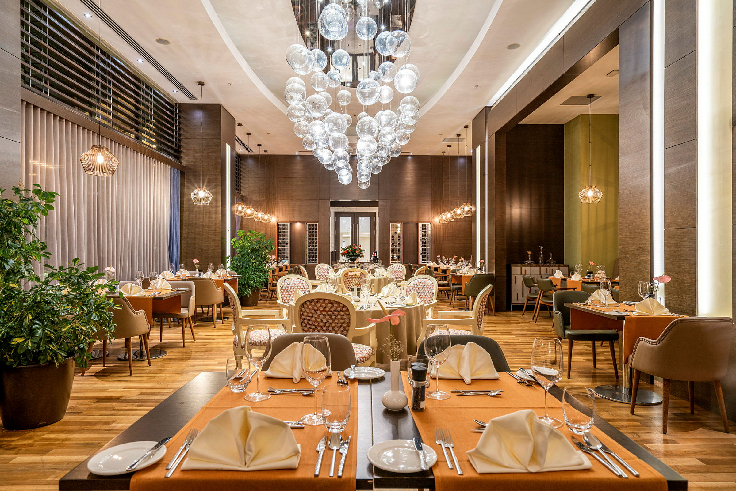 En elegant restaurant med dekkede bord, stoler og en dekorativ lysekrone. (AI-generert tekst)