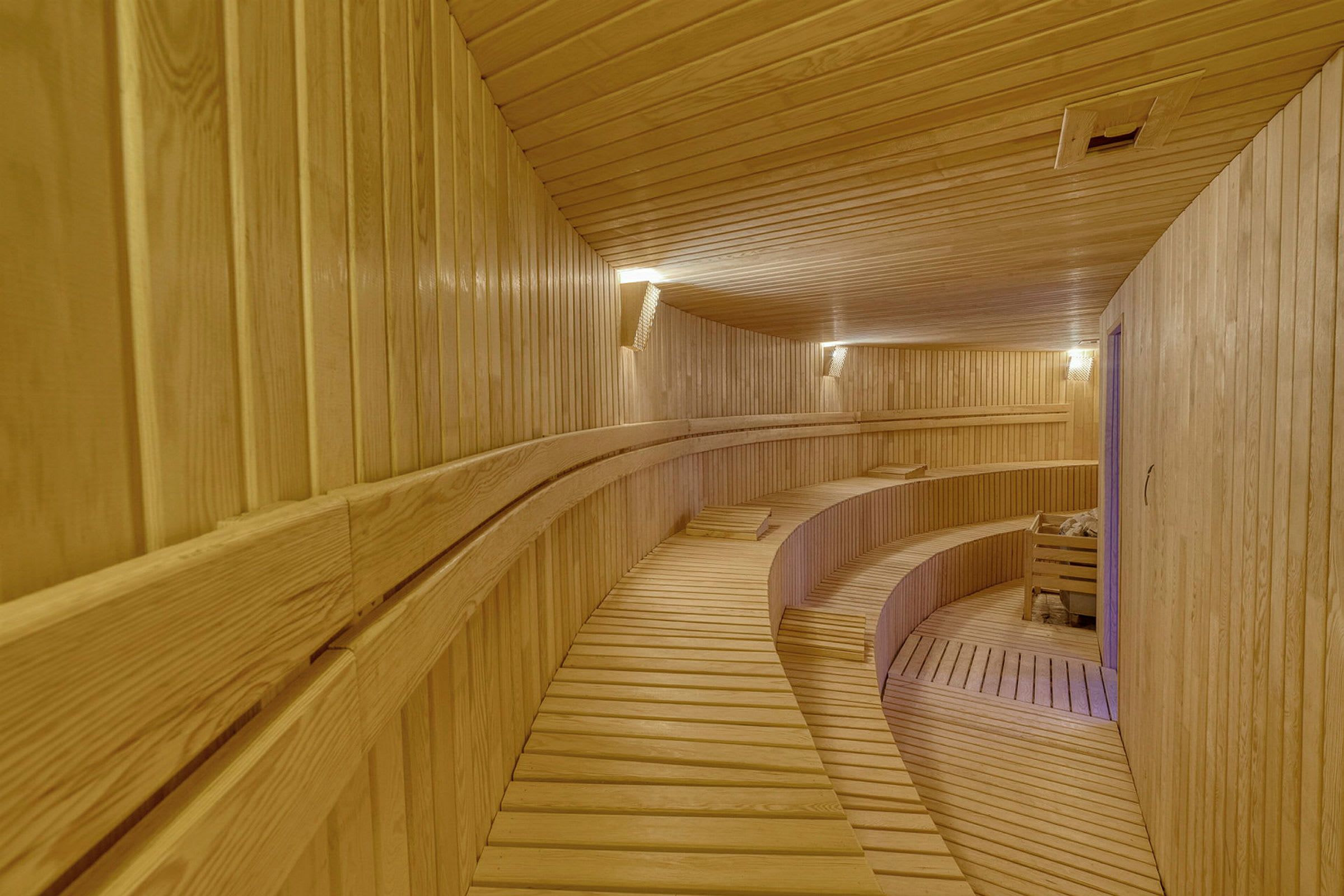 Interiør av en sauna i tre med sitteplasser i nivåer. (AI-generert tekst)