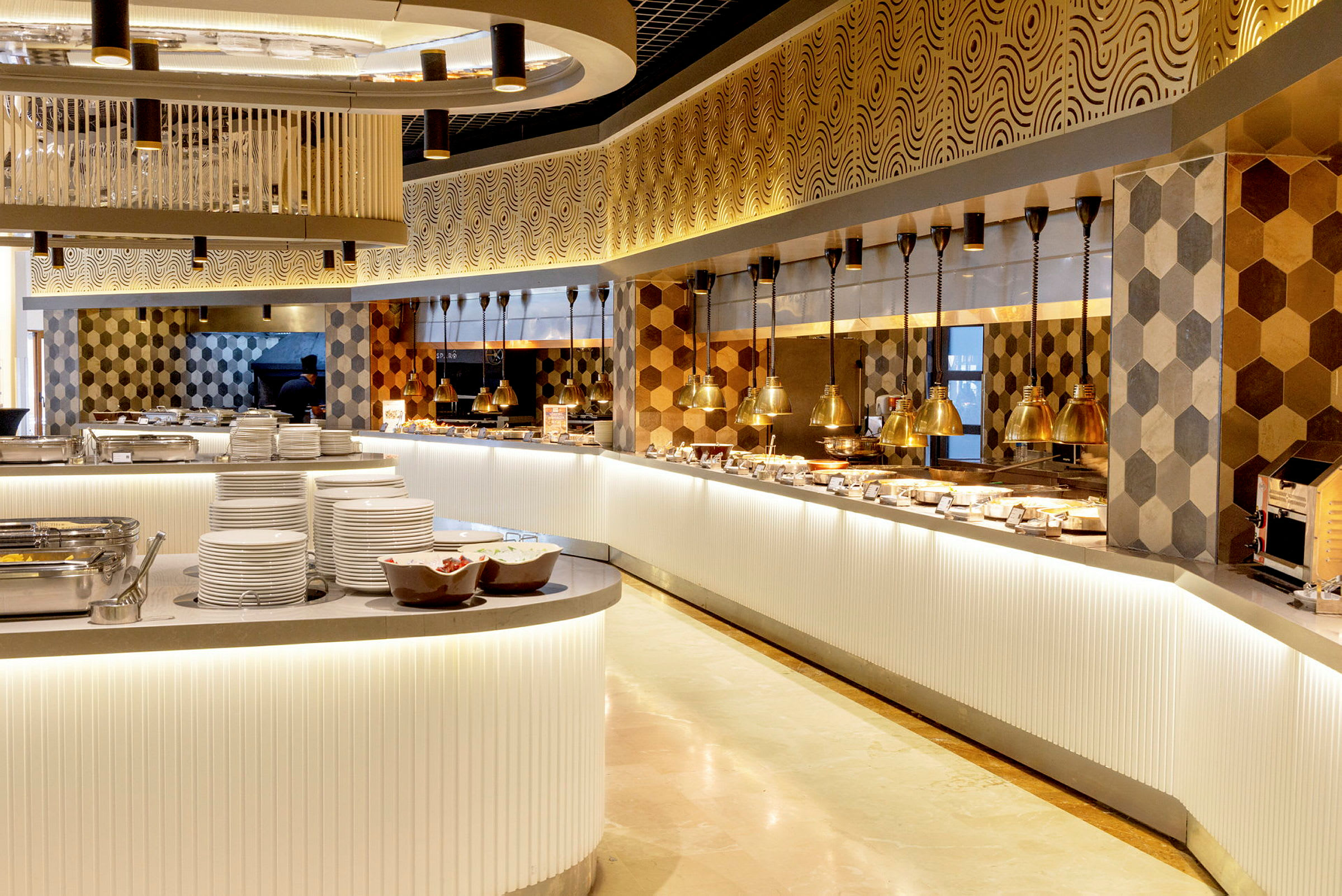 En elegant buffetoppsett i en restaurant med moderne, varme farger og heksagonale fliser på veggen. (AI-generert tekst)
