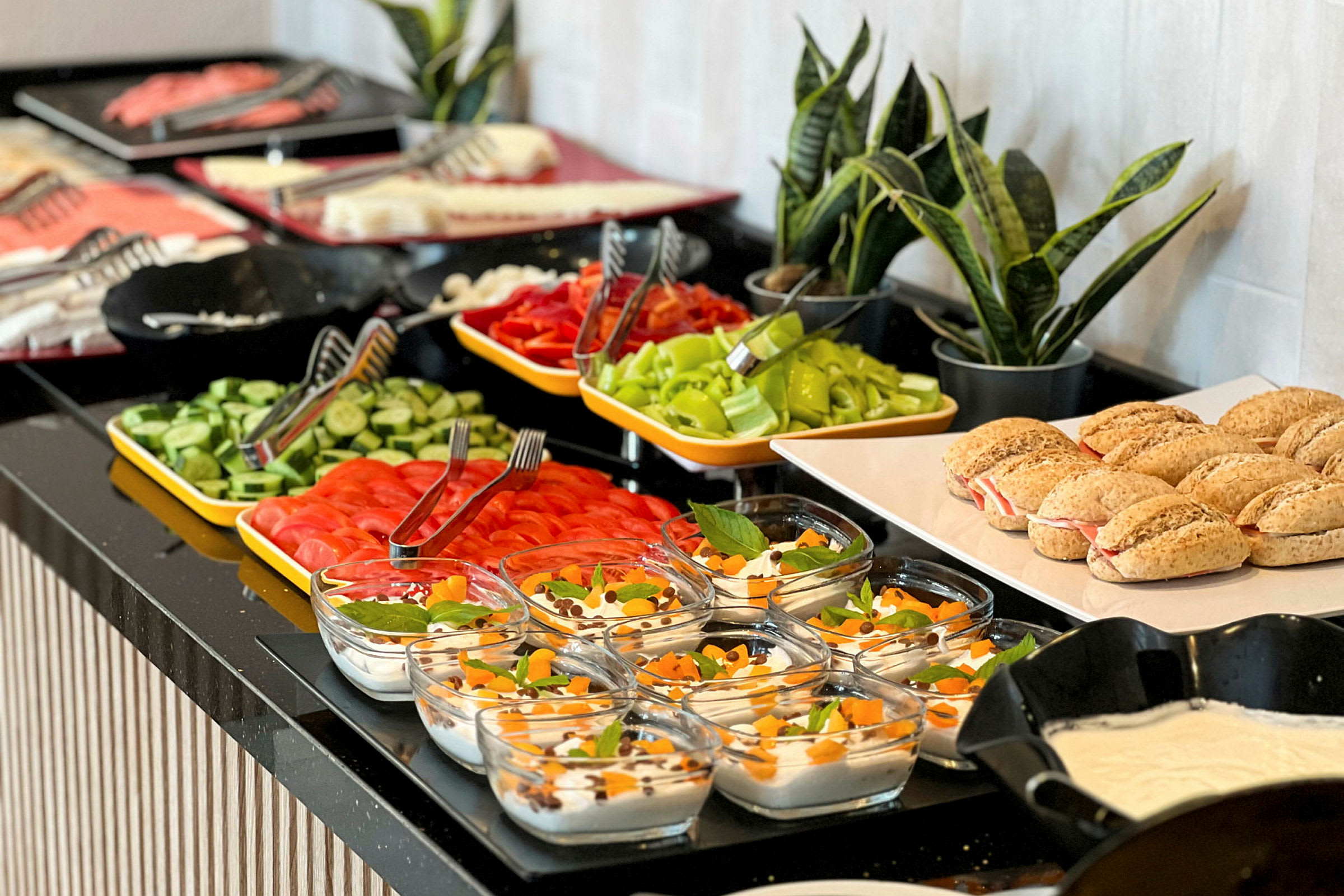 Bilde av en buffet med ulike matretter inkludert brød, grønnsaker og desserter. (AI-generert tekst)