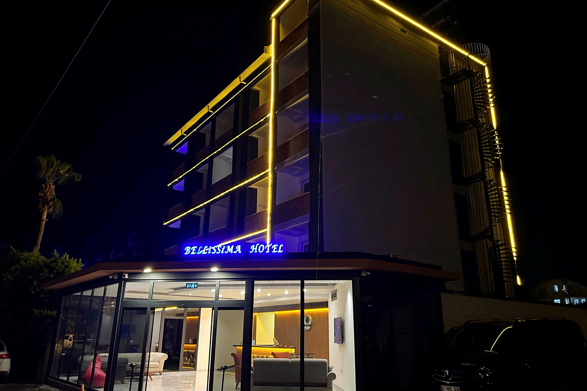 Hotellbygning med lysende skilt og fasadebelysning, fotografert om natten. (AI-generert tekst)