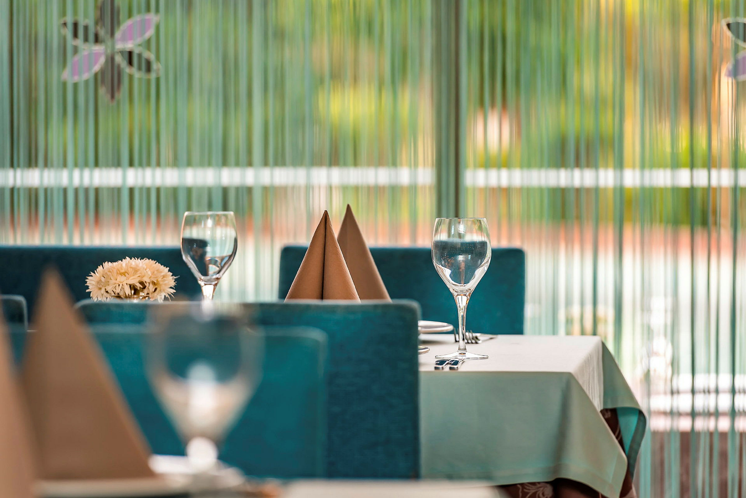 Pent dekket bord med glass og servietter i restaurantmiljø. (AI-generert tekst)