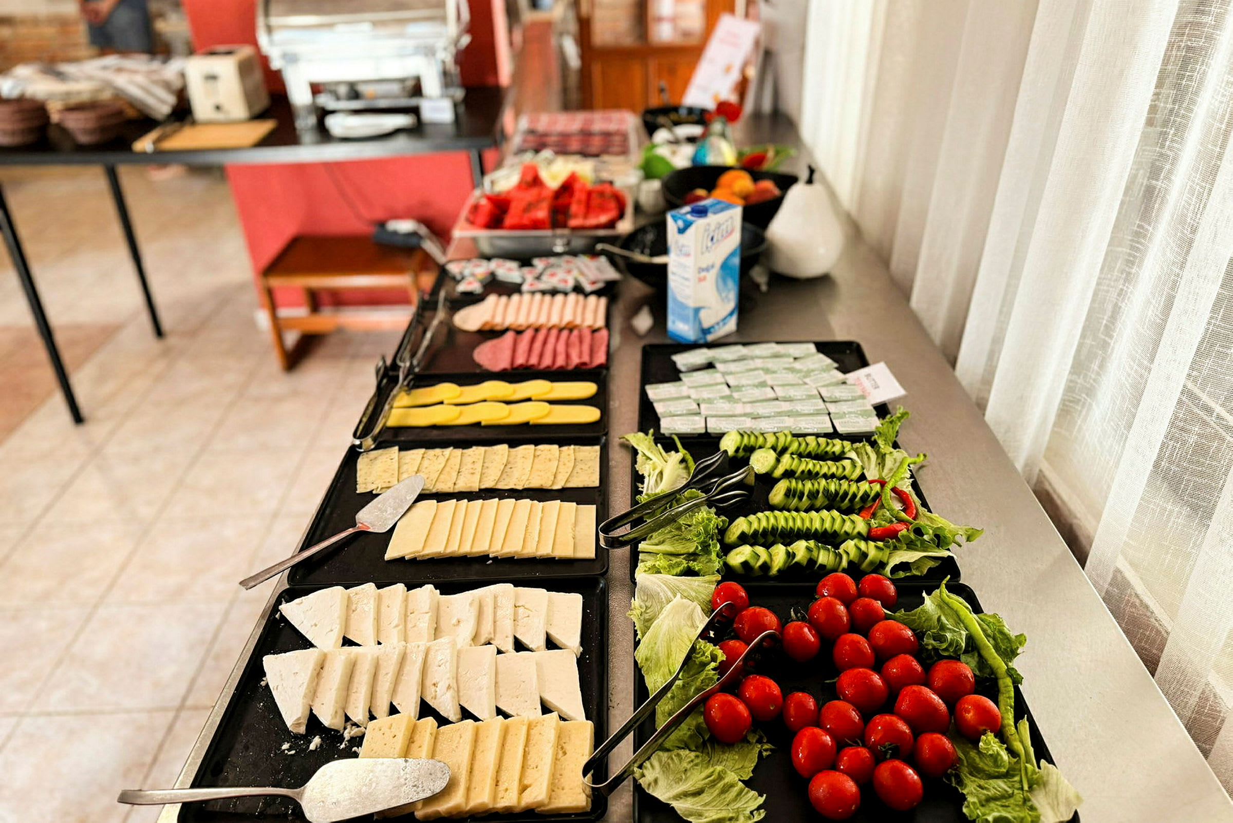 En frokostbuffé med ost, grønnsaker og andre tilbehør. (AI-generert tekst)