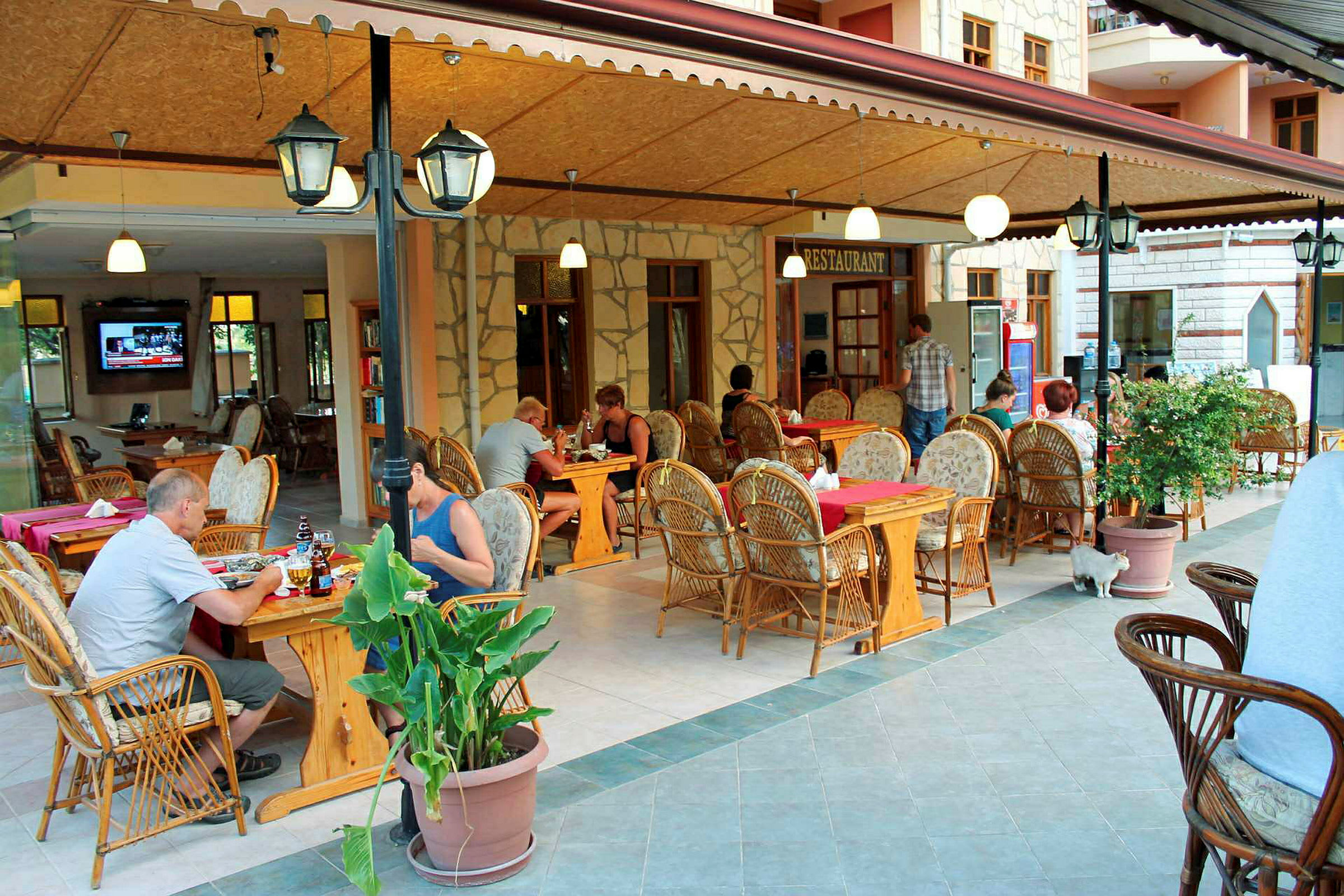 En restaurant med uteservering og møbler av rotting. (AI-generert tekst)