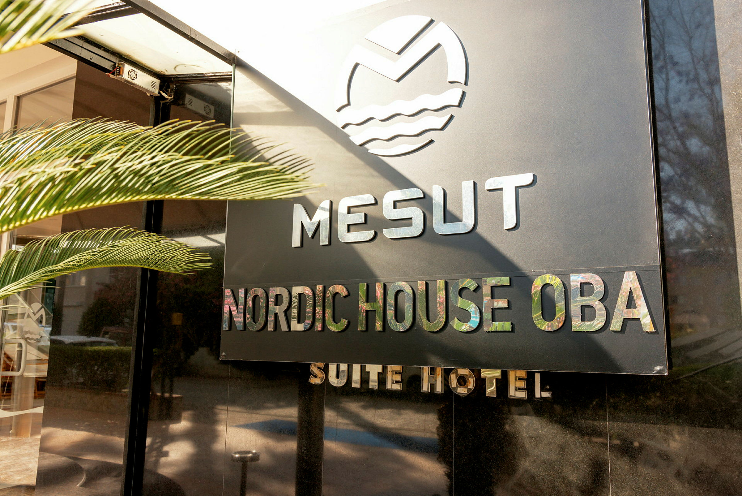 Hotellskilt med teksten Mesut Nordic House Oba Suite Hotel. (AI-generert tekst)
