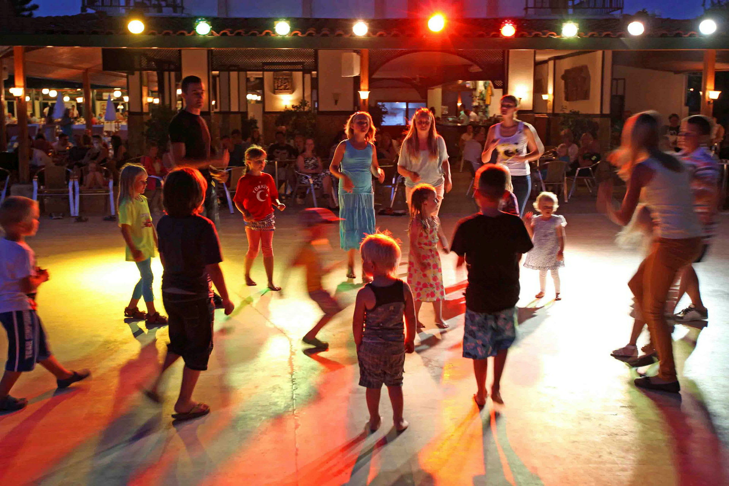 Barn danser på en opplyst overflate om kvelden. (AI-generert tekst)