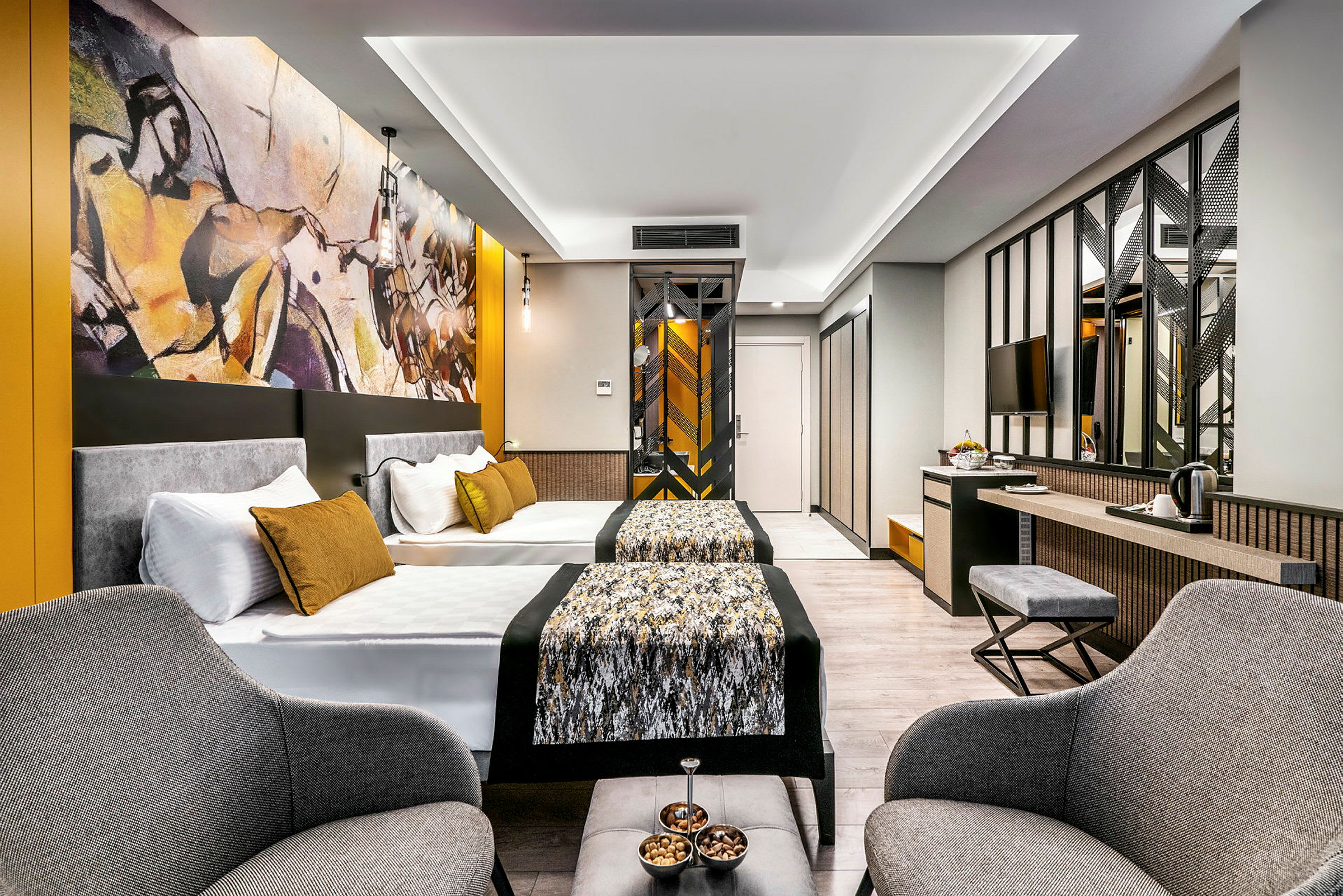 Moderne hotellrom med to senger, sittegruppe og kunst på veggen. (AI-generert tekst)