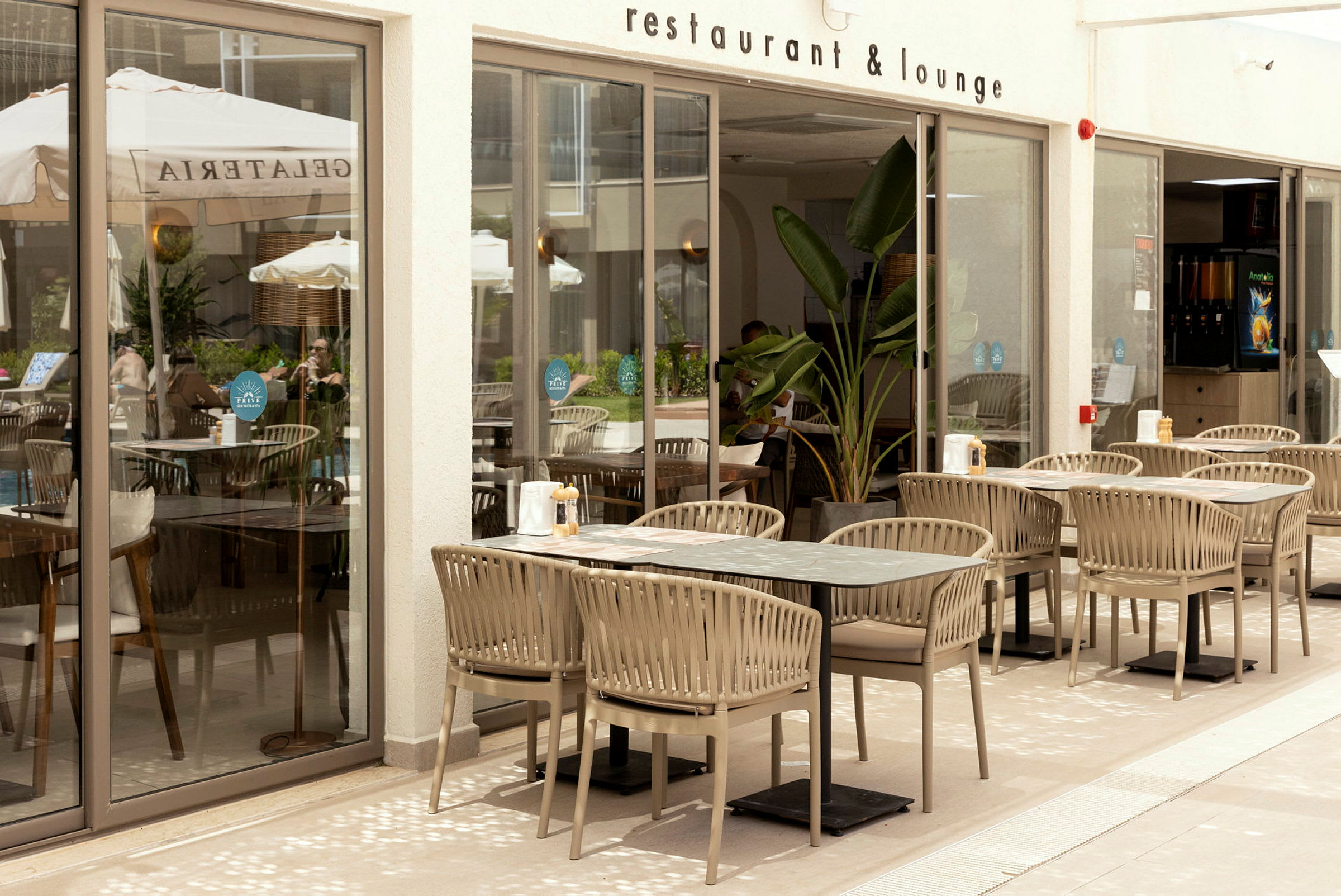 Uteområdet til en restaurant med bord og stoler plassert på en terrasse. (AI-generert tekst)