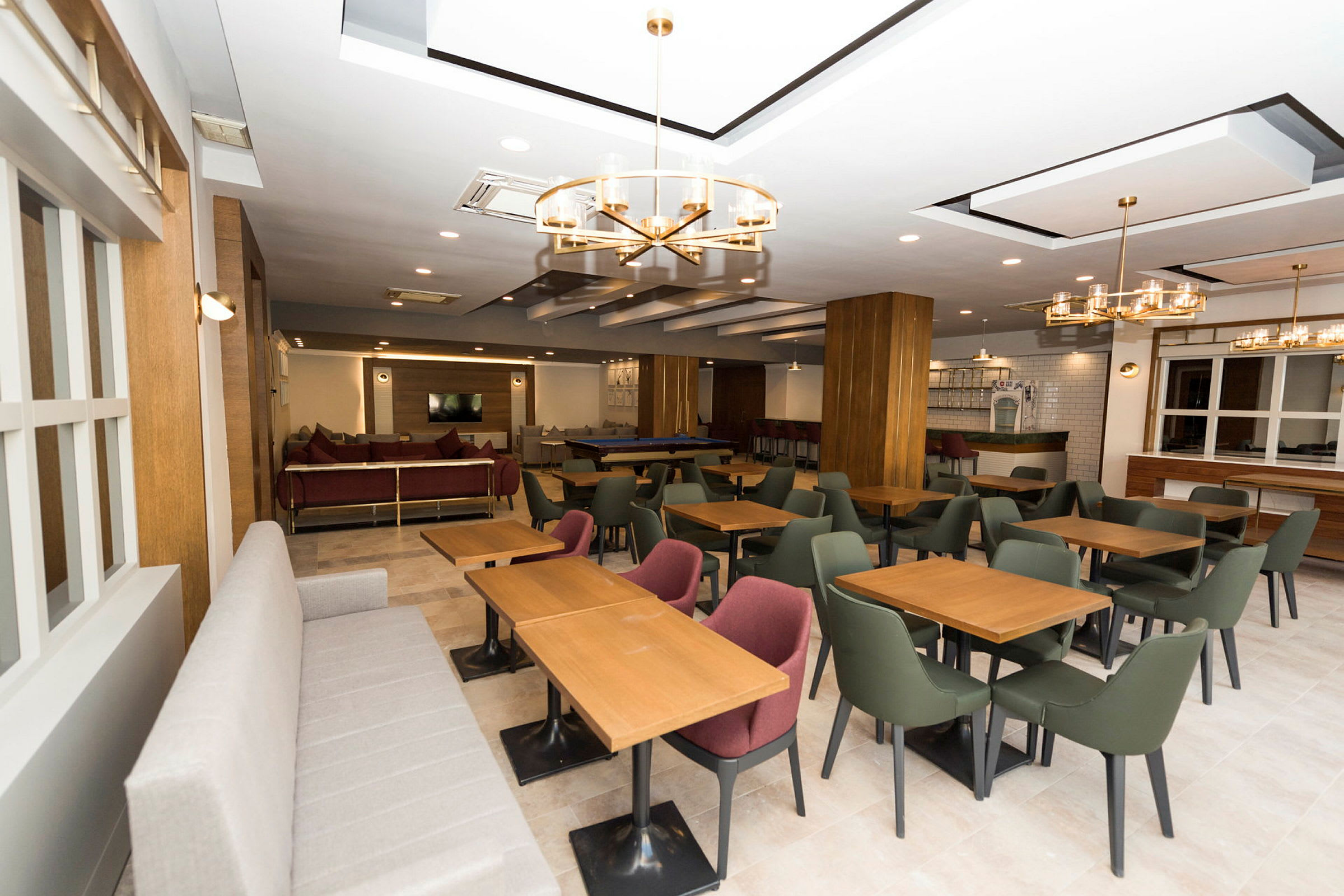 En moderne restaurant med bord, stoler og sofaer. (AI-generert tekst)