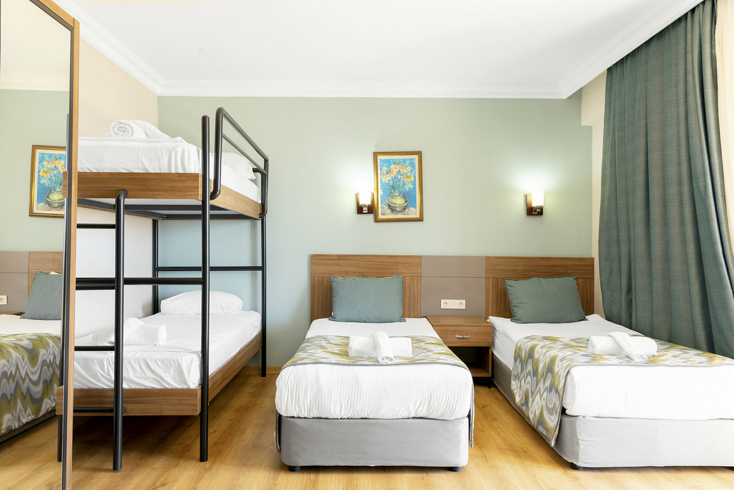 Hotellrom med køyeseng og to enkeltsenger. (AI-generert tekst)