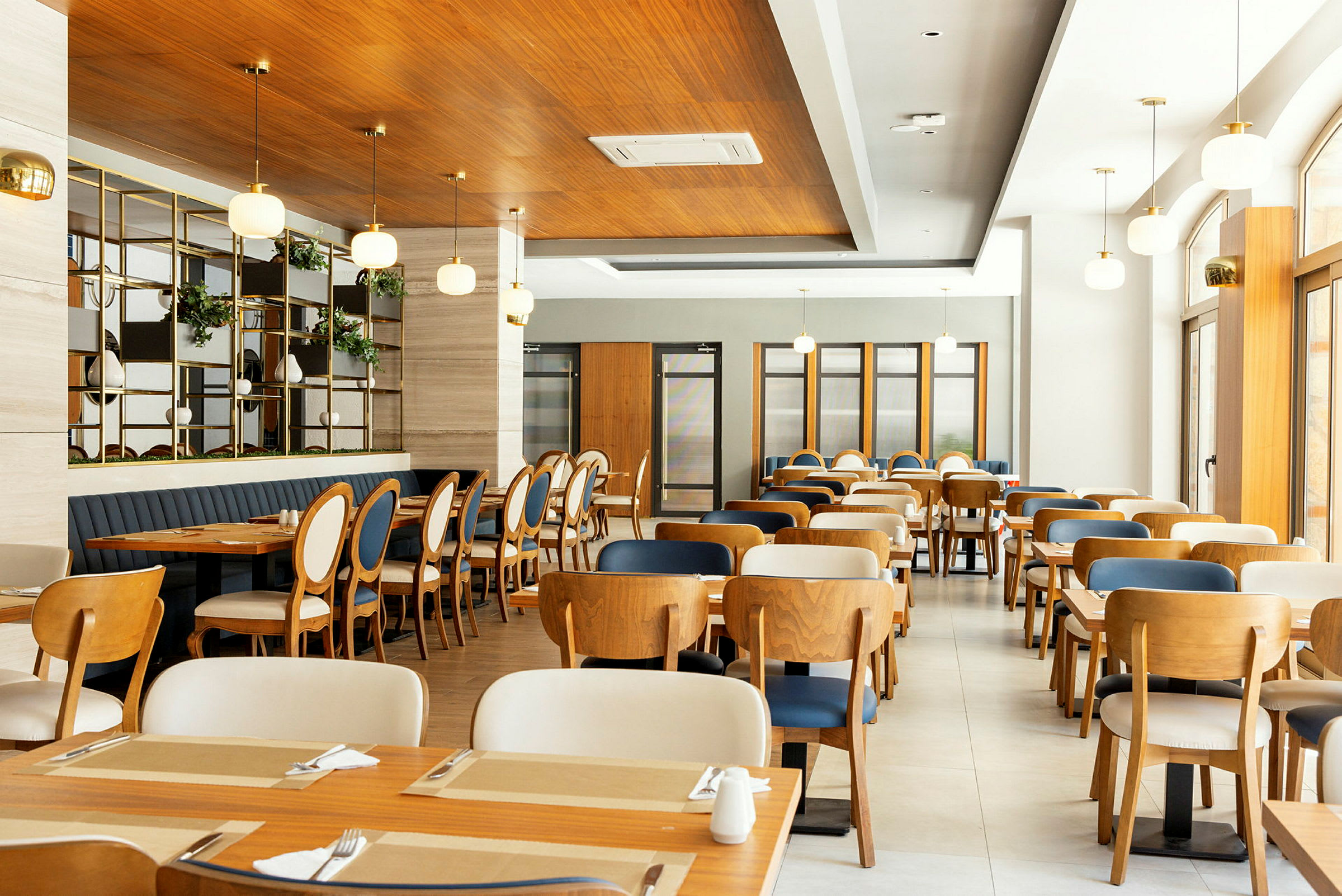 Interiør av en moderne restaurant med trebord og stoler. (AI-generert tekst)